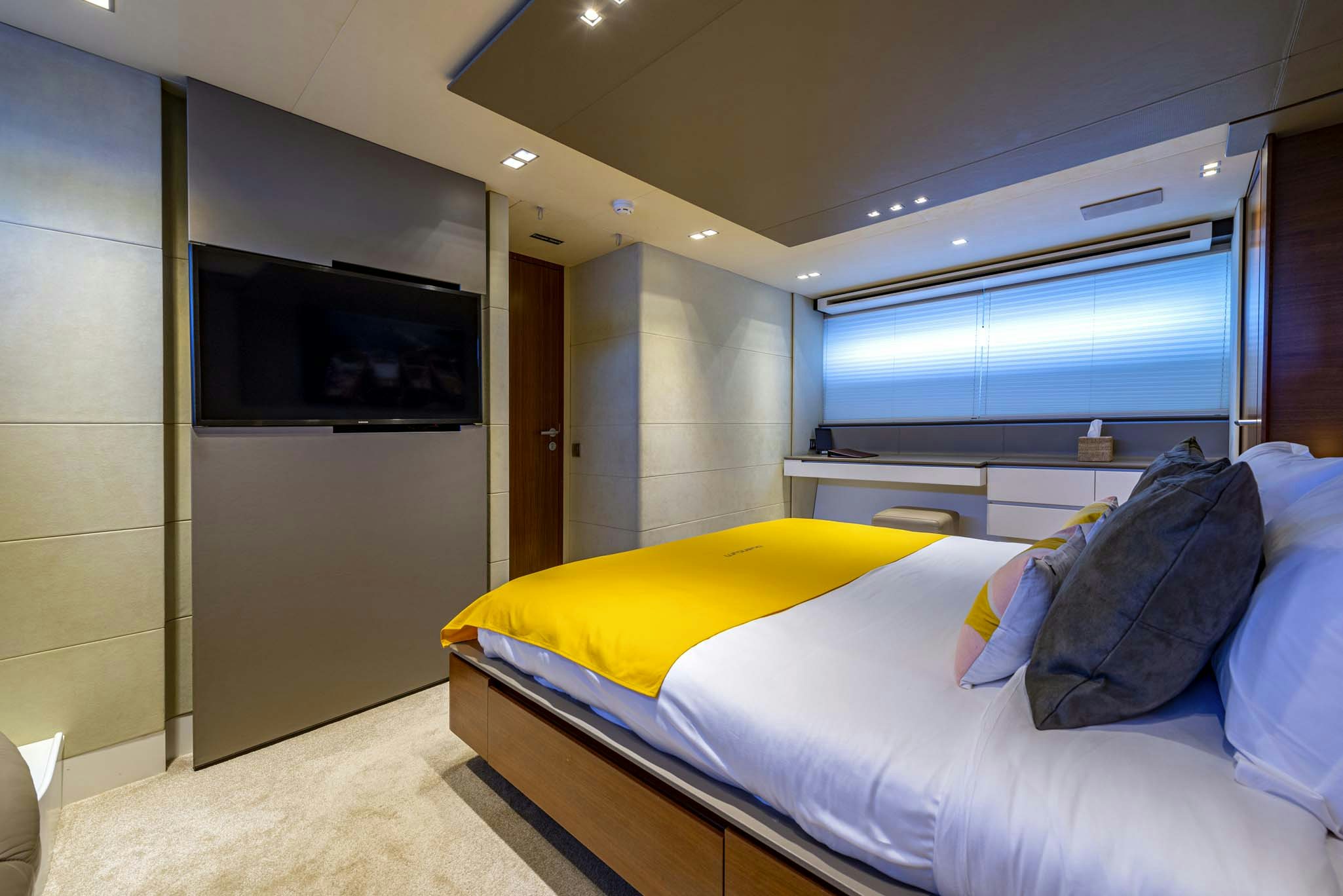 a bedroom with a bed and a tv aboard QUANTUM Yacht for Charter
