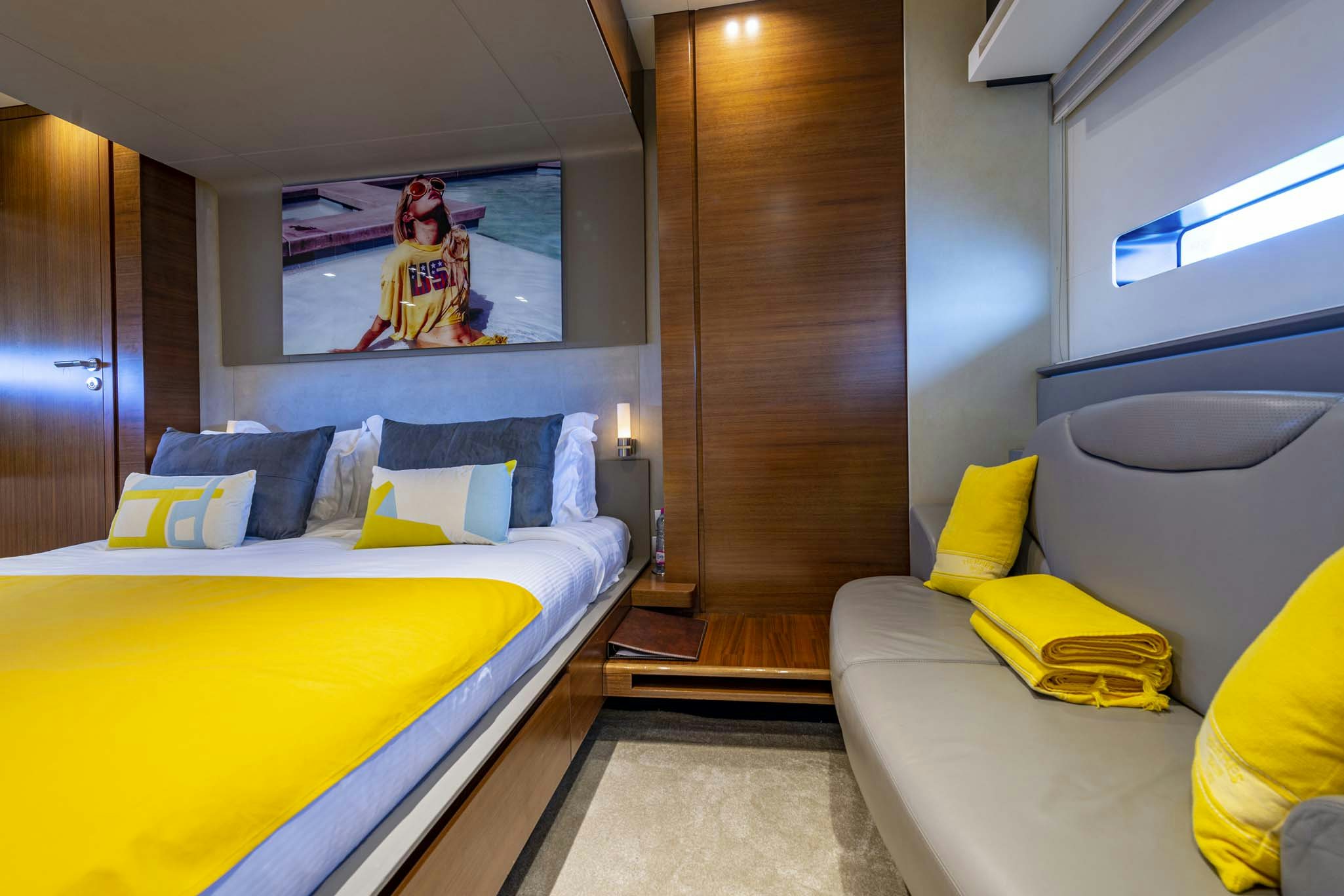 a bedroom with a bed and a television on the wall aboard QUANTUM Yacht for Charter