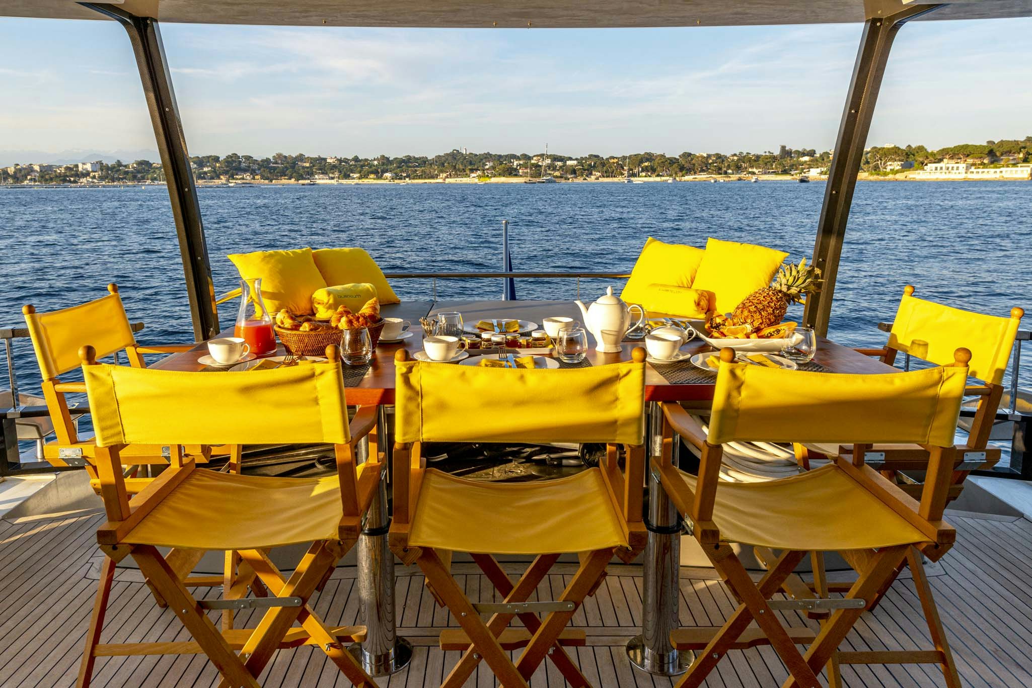 a table set for a meal on a deck overlooking the ocean aboard QUANTUM Yacht for Charter