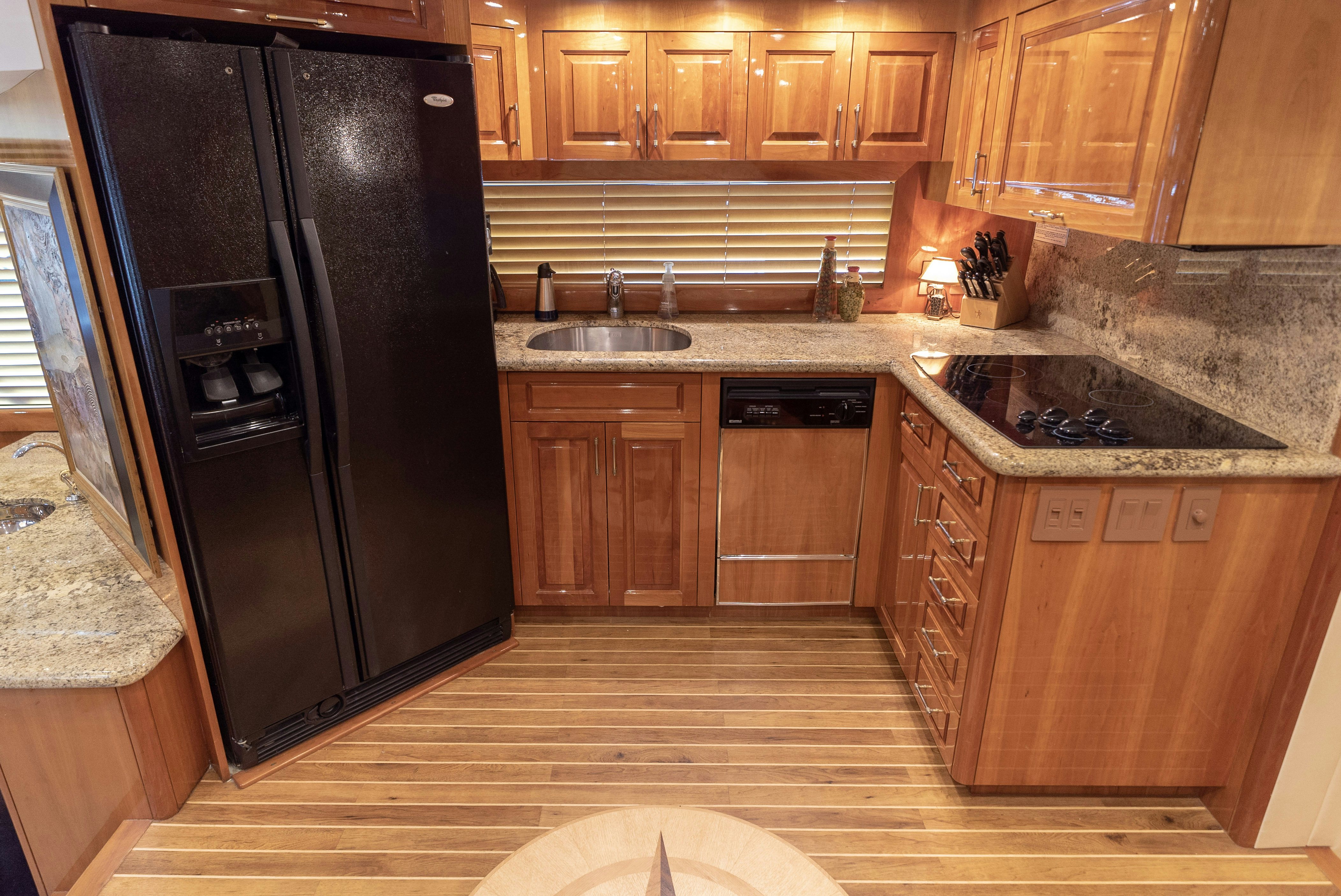 a kitchen with black appliances aboard SONORA Yacht for Sale
