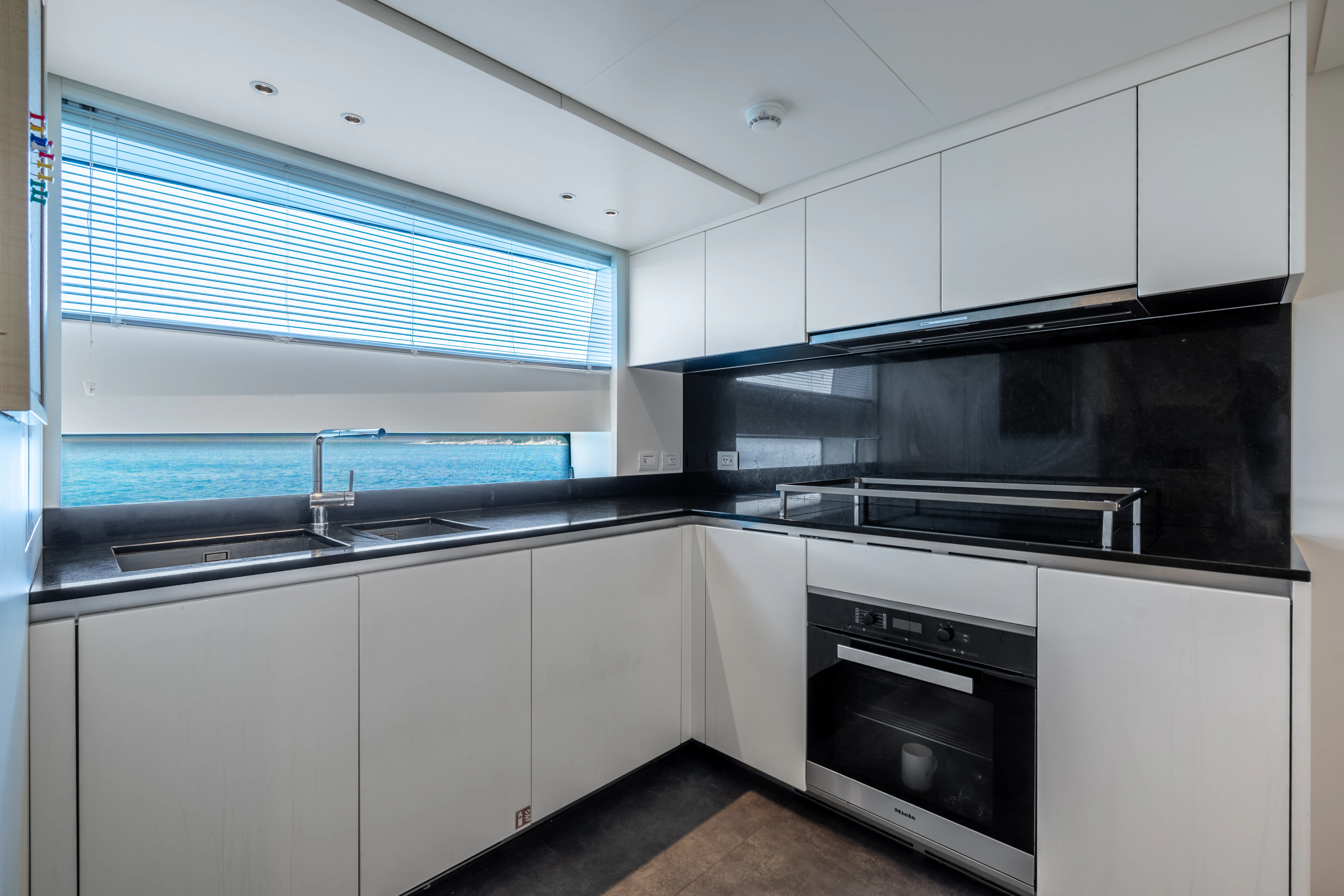 a kitchen with white cabinets aboard AISHA Yacht for Sale