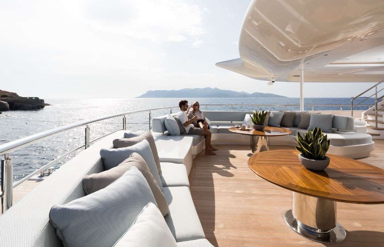 a couple sitting on a couch aboard O'PARI Yacht for Charter