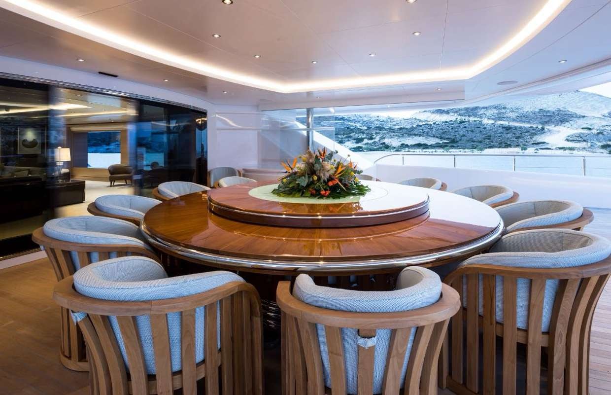 a table with chairs around it aboard O'PARI Yacht for Charter