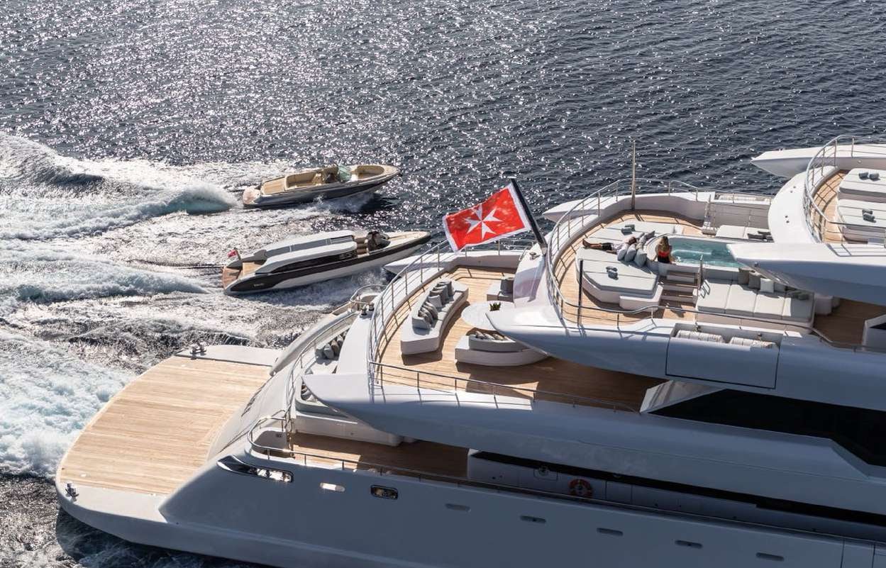 a boat with a flag on it aboard O'PARI Yacht for Charter
