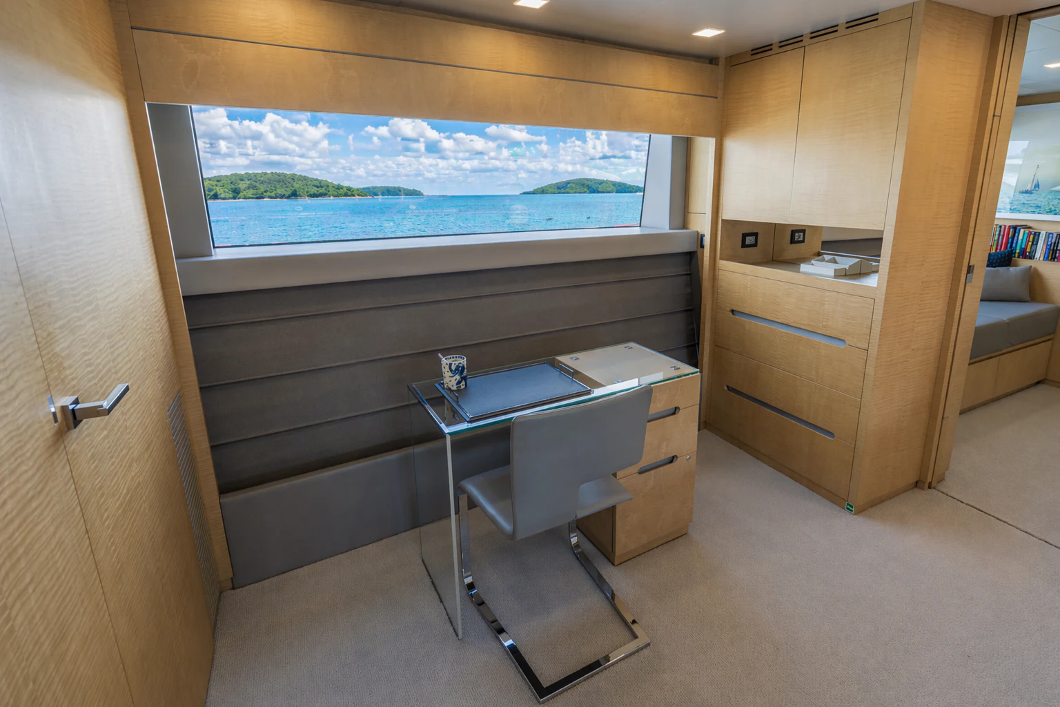 a room with a desk and a window aboard 'H Yacht for Charter