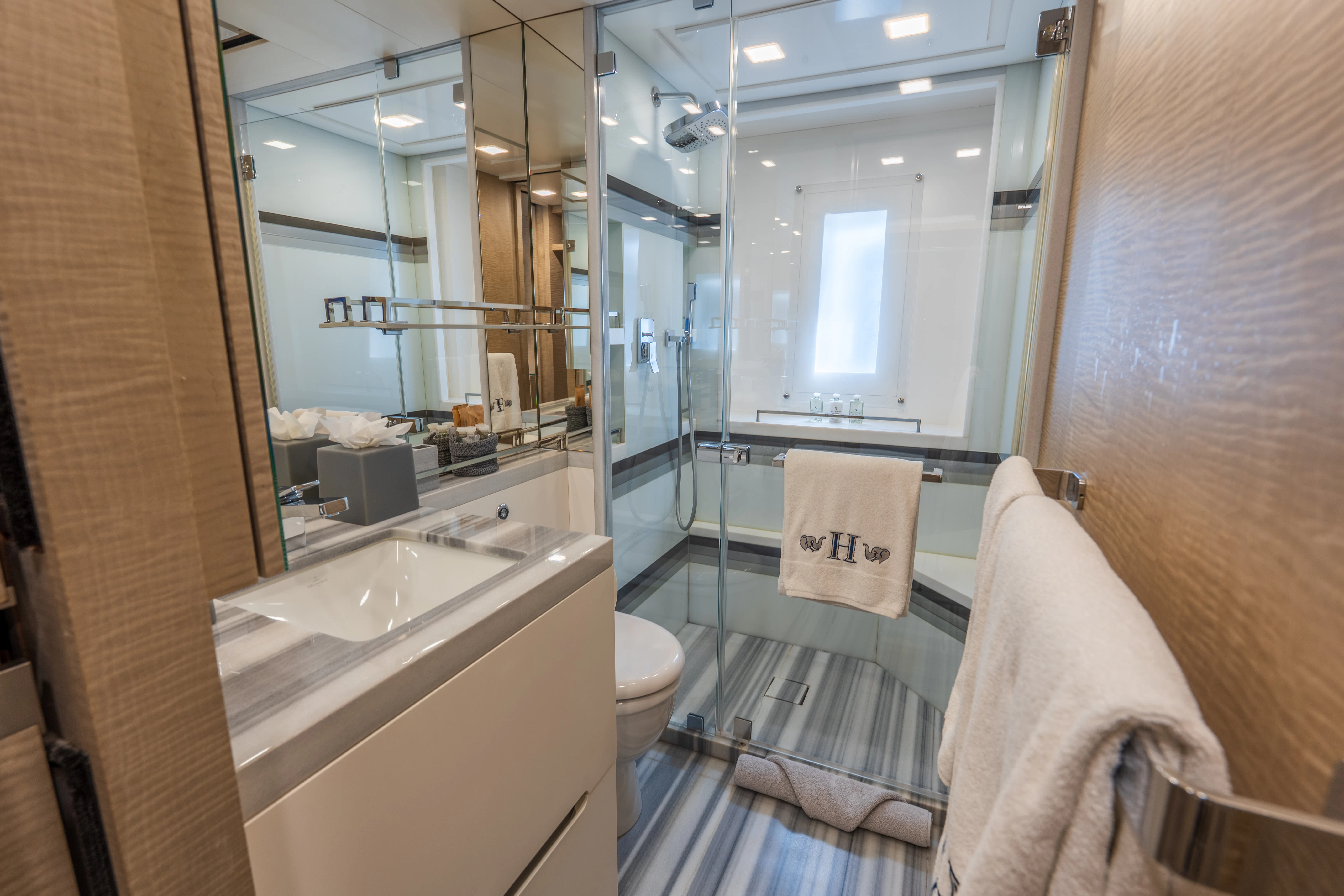 a bathroom with a glass shower aboard 'H Yacht for Charter