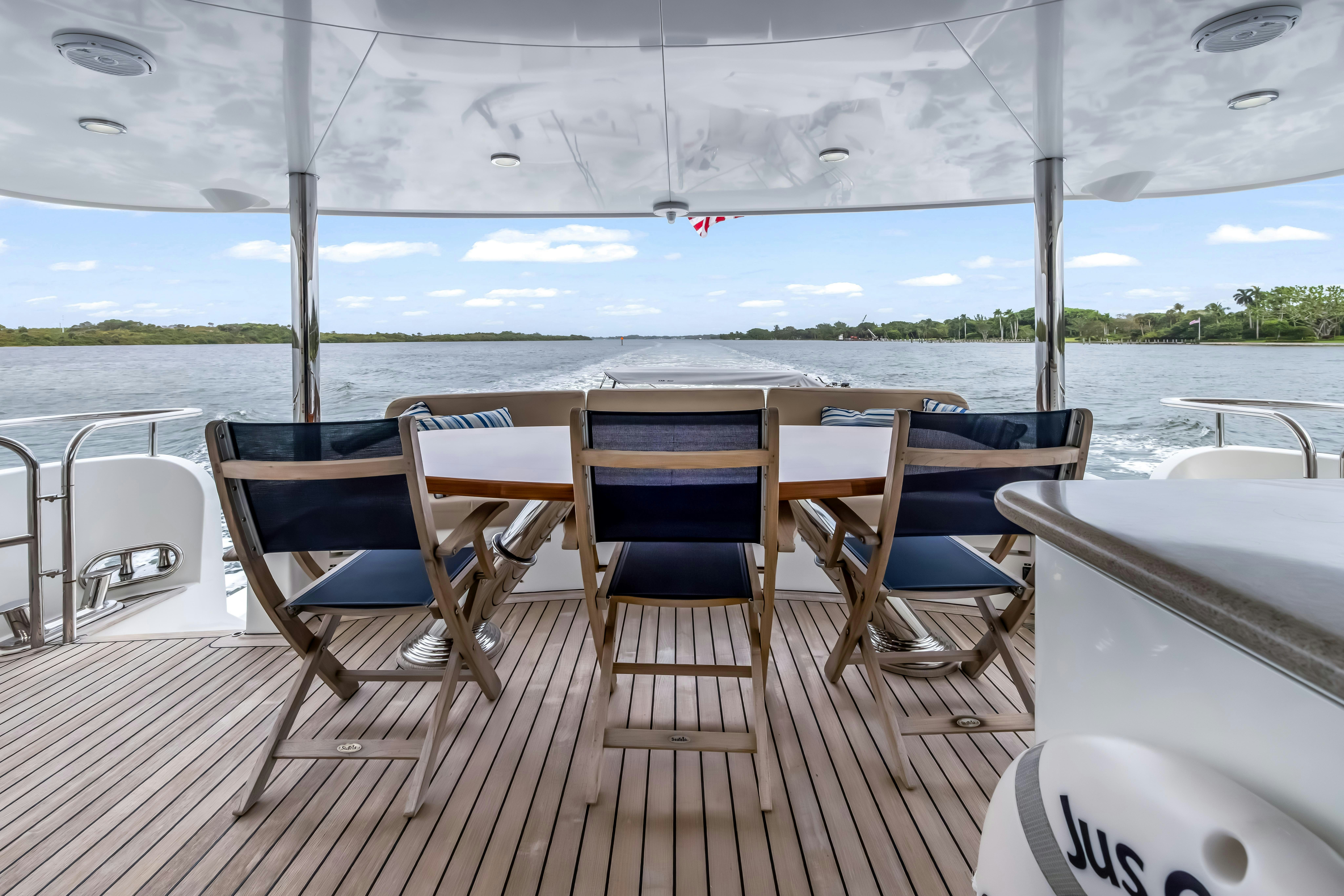 a deck with chairs and tables on it aboard AURORA Yacht for Sale