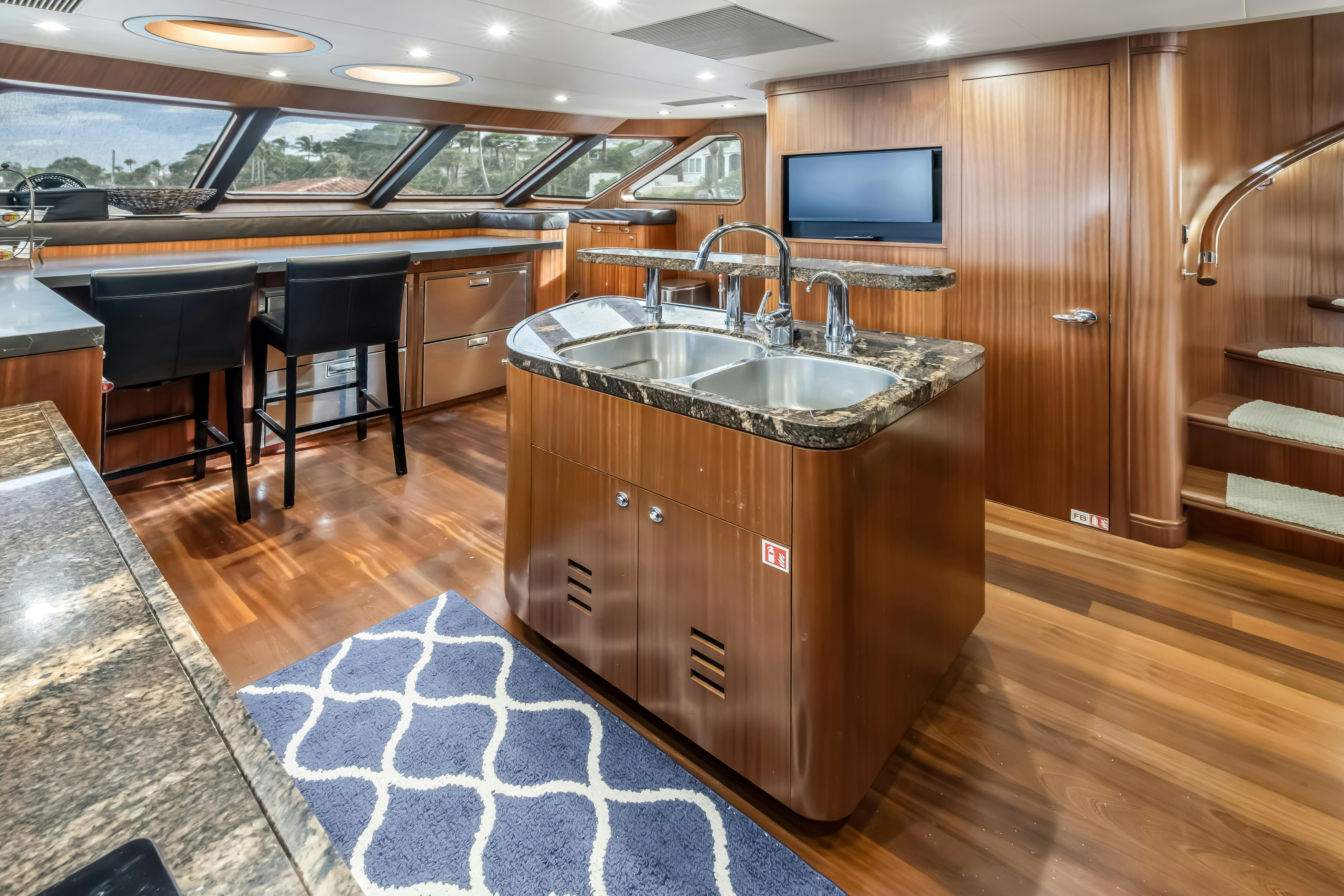 a kitchen with a sink and a tv aboard AURORA Yacht for Sale
