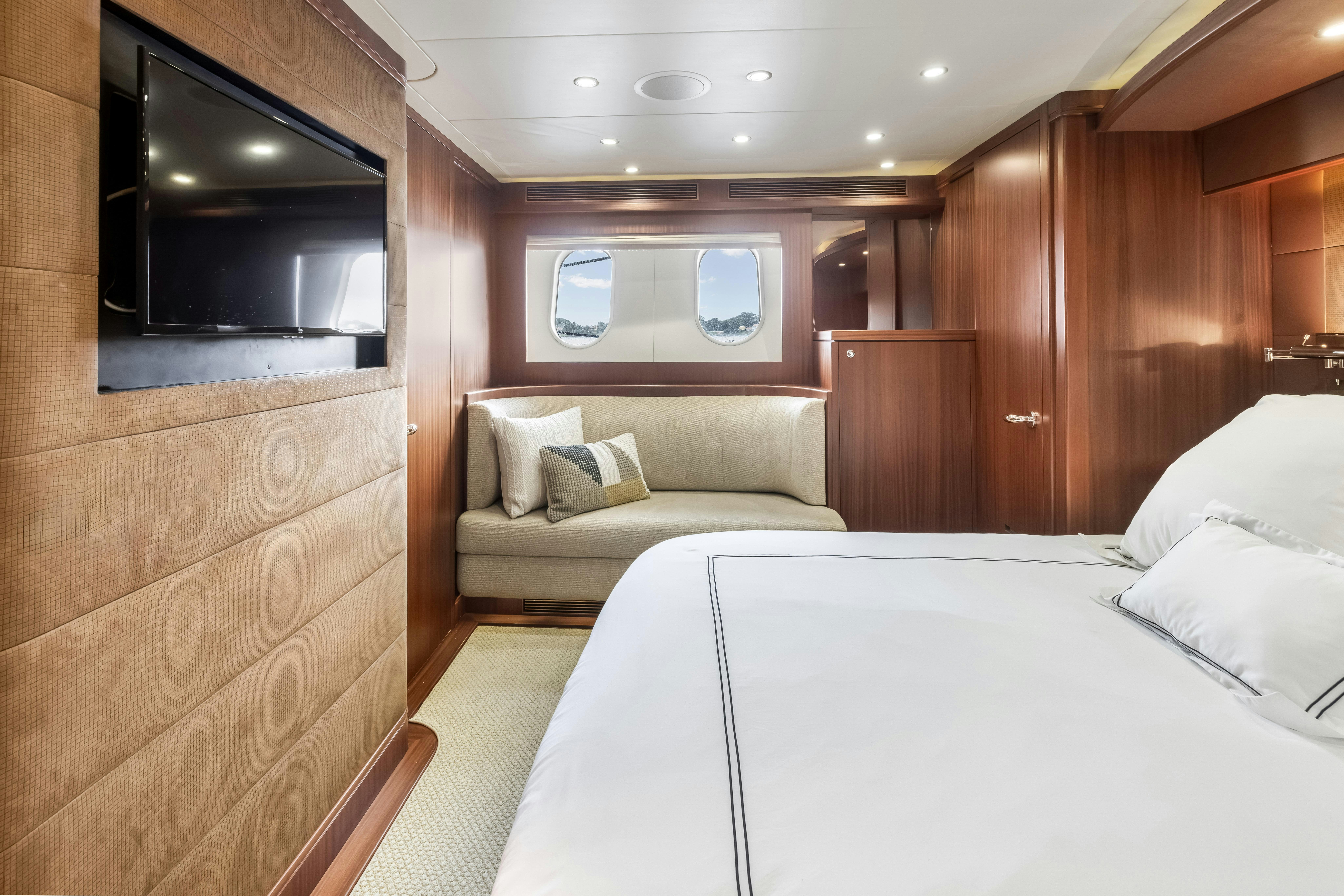 a room with a bed and a television aboard AURORA Yacht for Sale