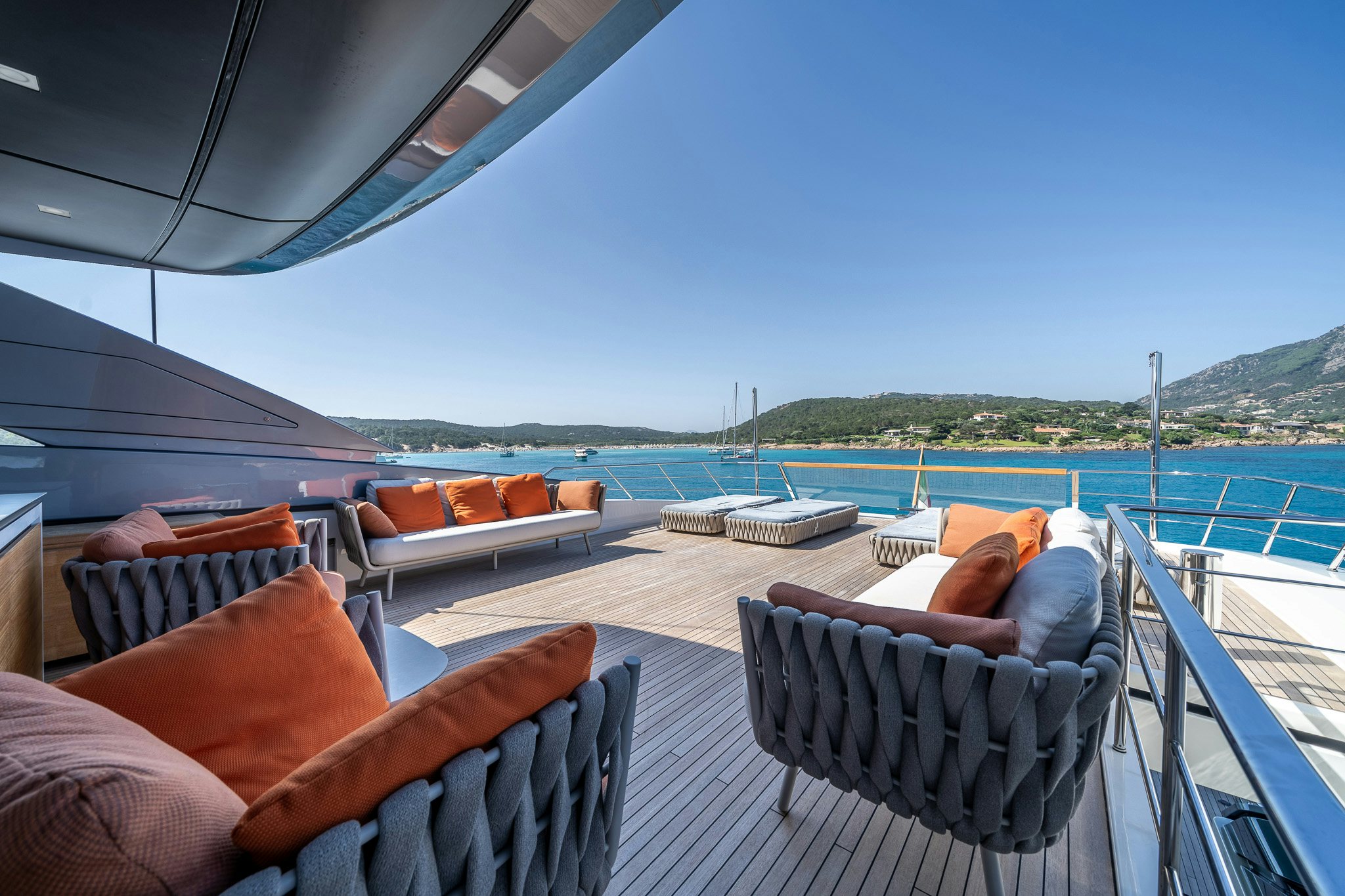 a deck with chairs and a body of water in the background aboard BLUE ANGEL Yacht for Sale