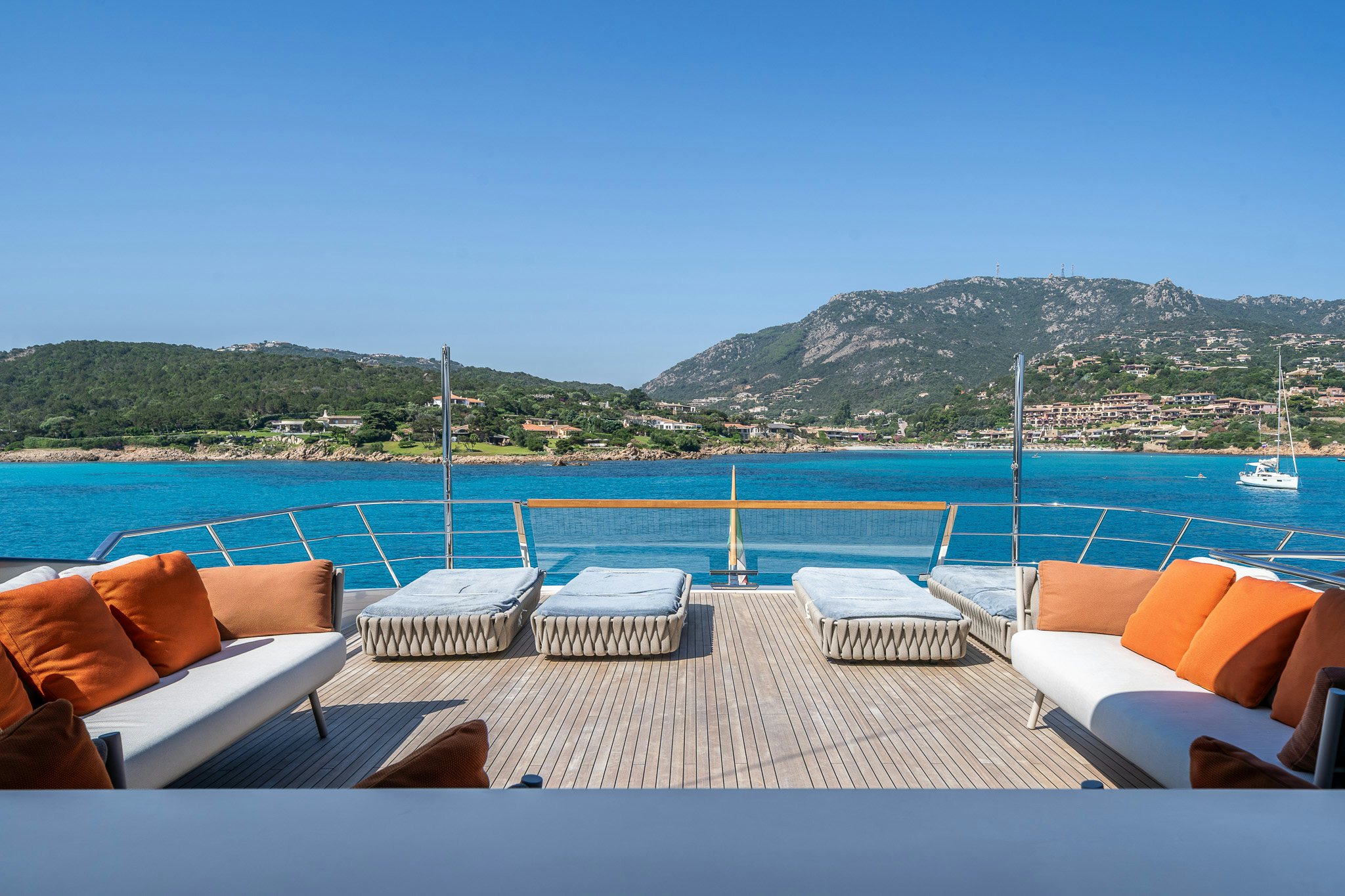 a lounge area with lounge chairs and a body of water in the background aboard BLUE ANGEL Yacht for Sale