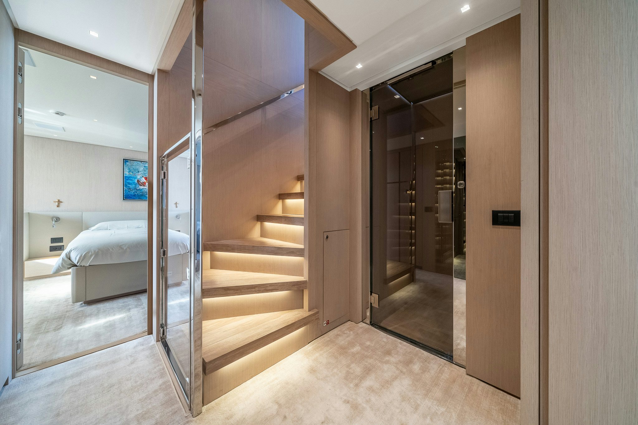 a modern bedroom with a glass door aboard BLUE ANGEL Yacht for Sale