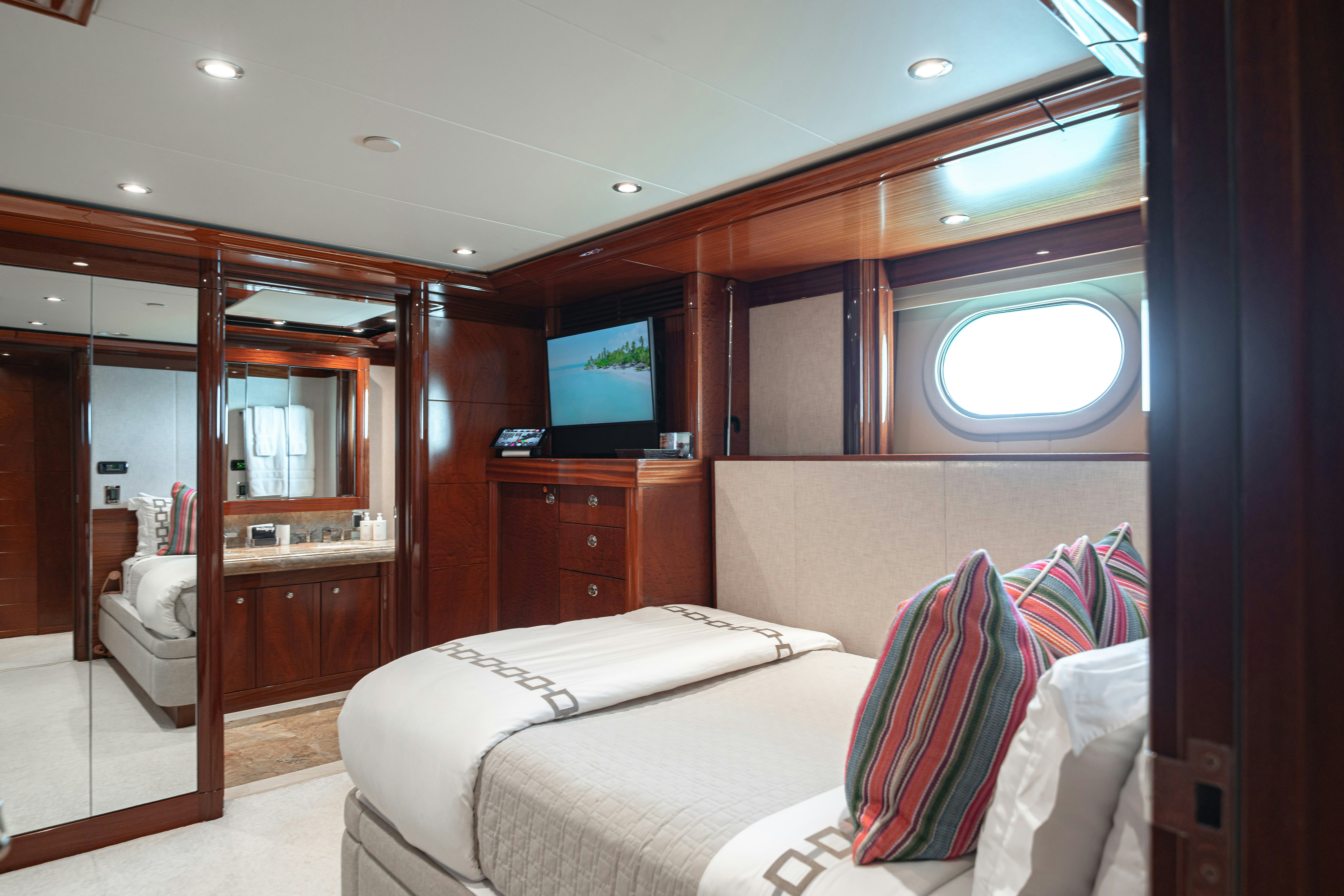 a bedroom with a bed and a tv aboard CHASING DAYLIGHT Yacht for Charter