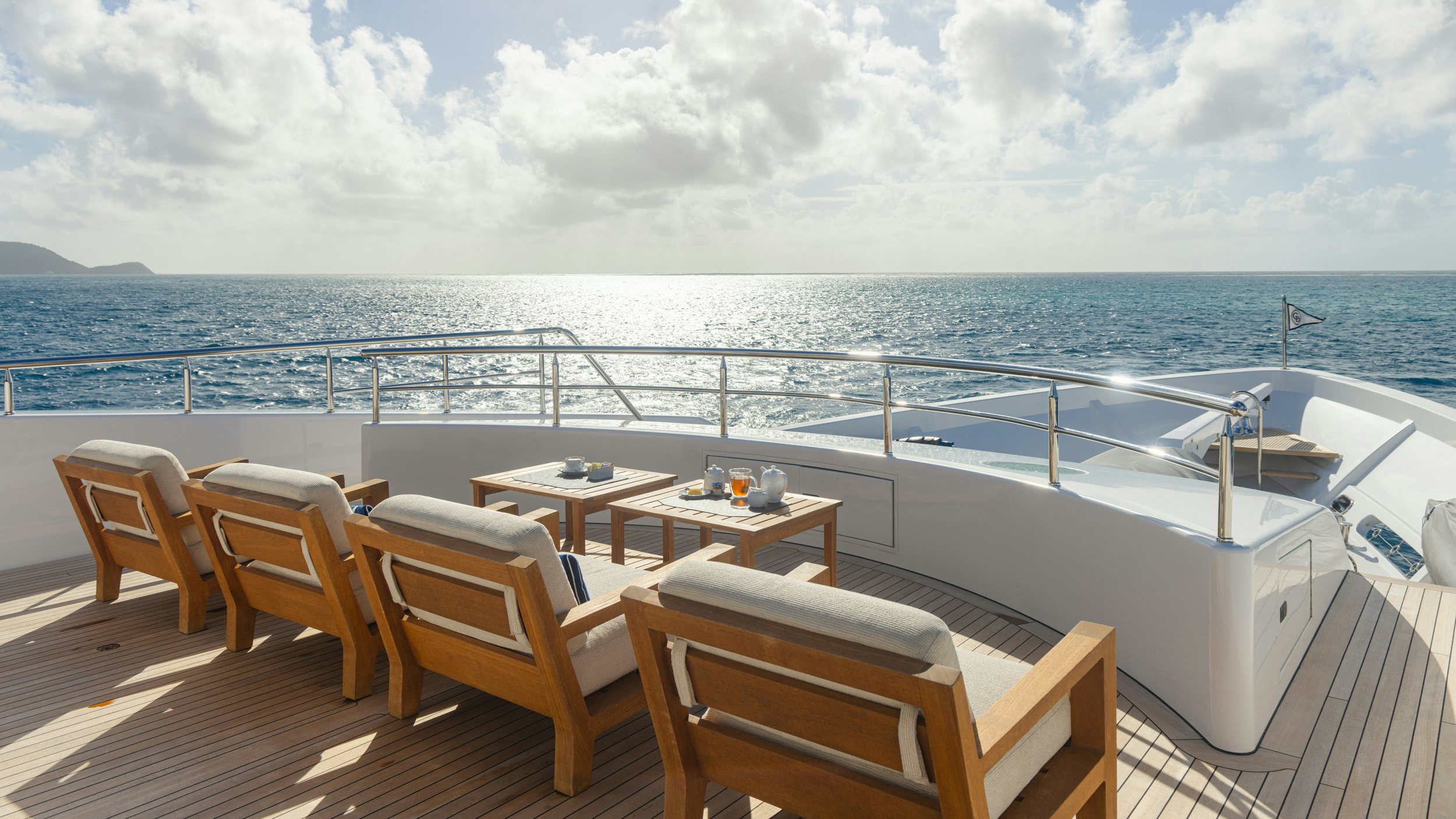 a table and chairs on a deck overlooking a large body of water aboard CHASING DAYLIGHT Yacht for Charter