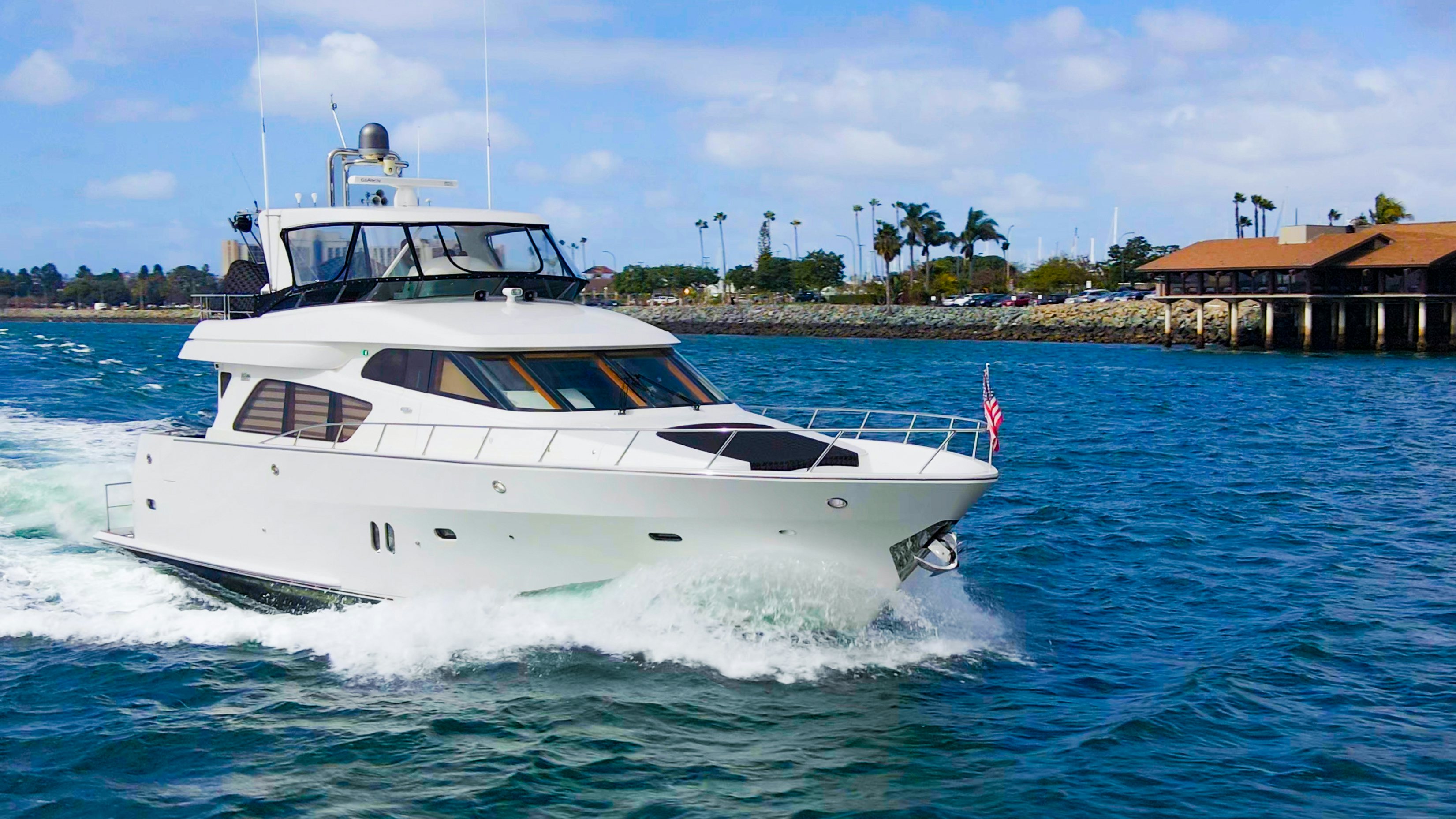 a white boat on the water aboard YOLO Yacht for Sale