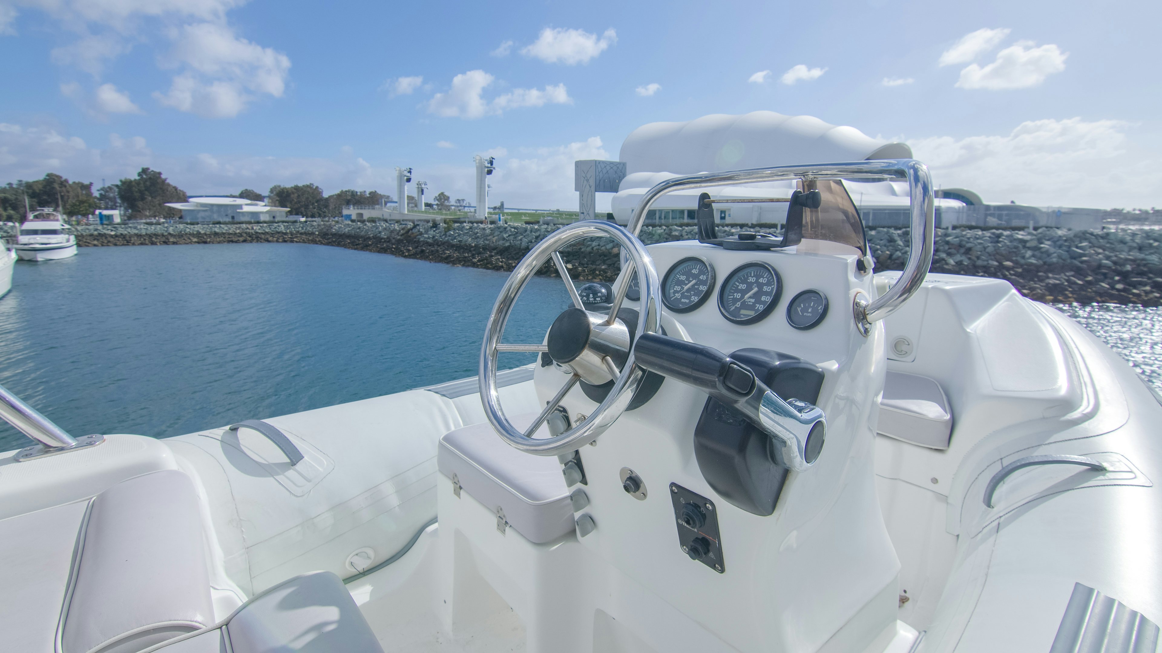 a boat with a steering wheel and a body of water in the background aboard YOLO Yacht for Sale
