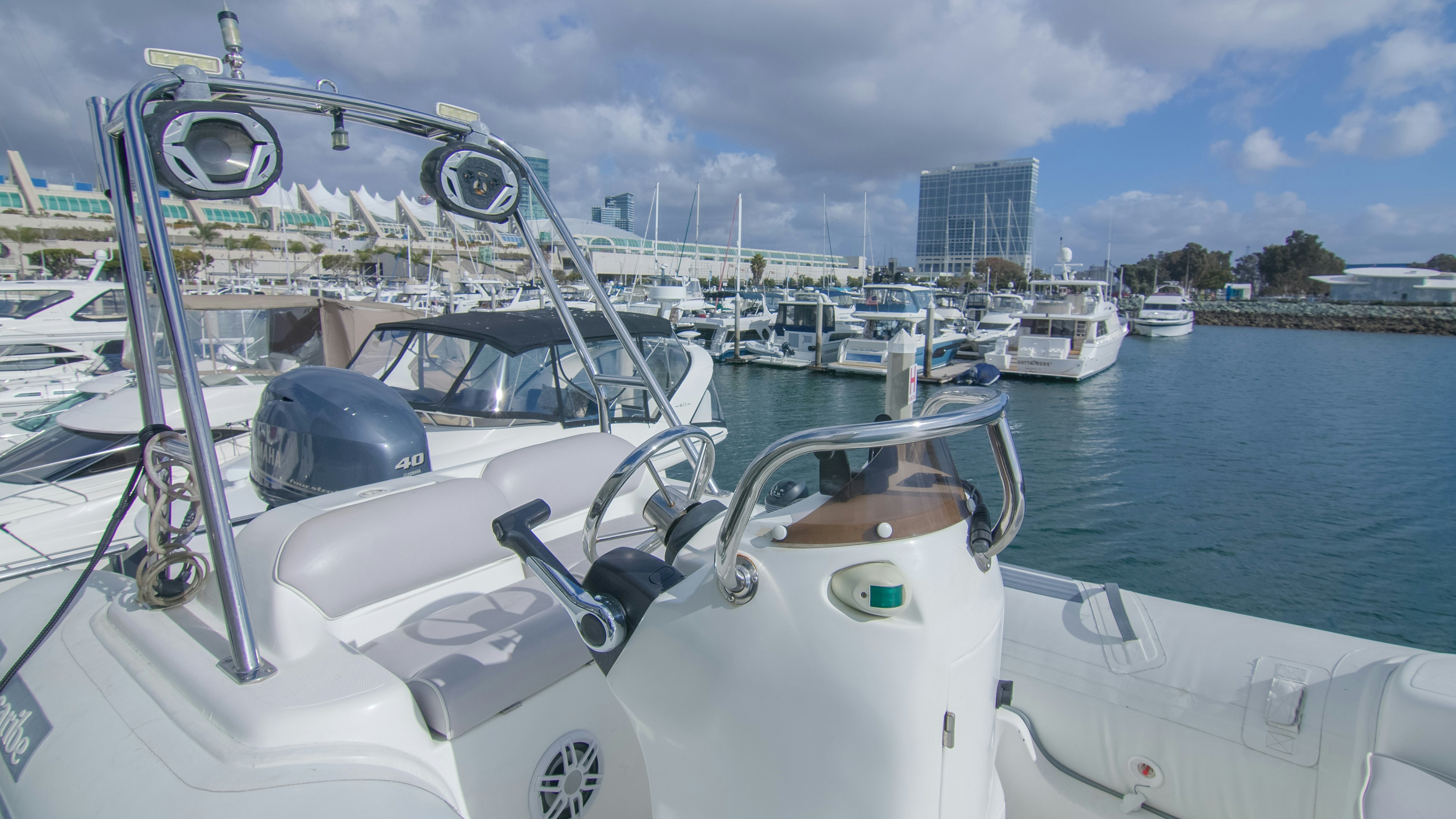 a boat with a steering wheel and other boats in the water aboard YOLO Yacht for Sale