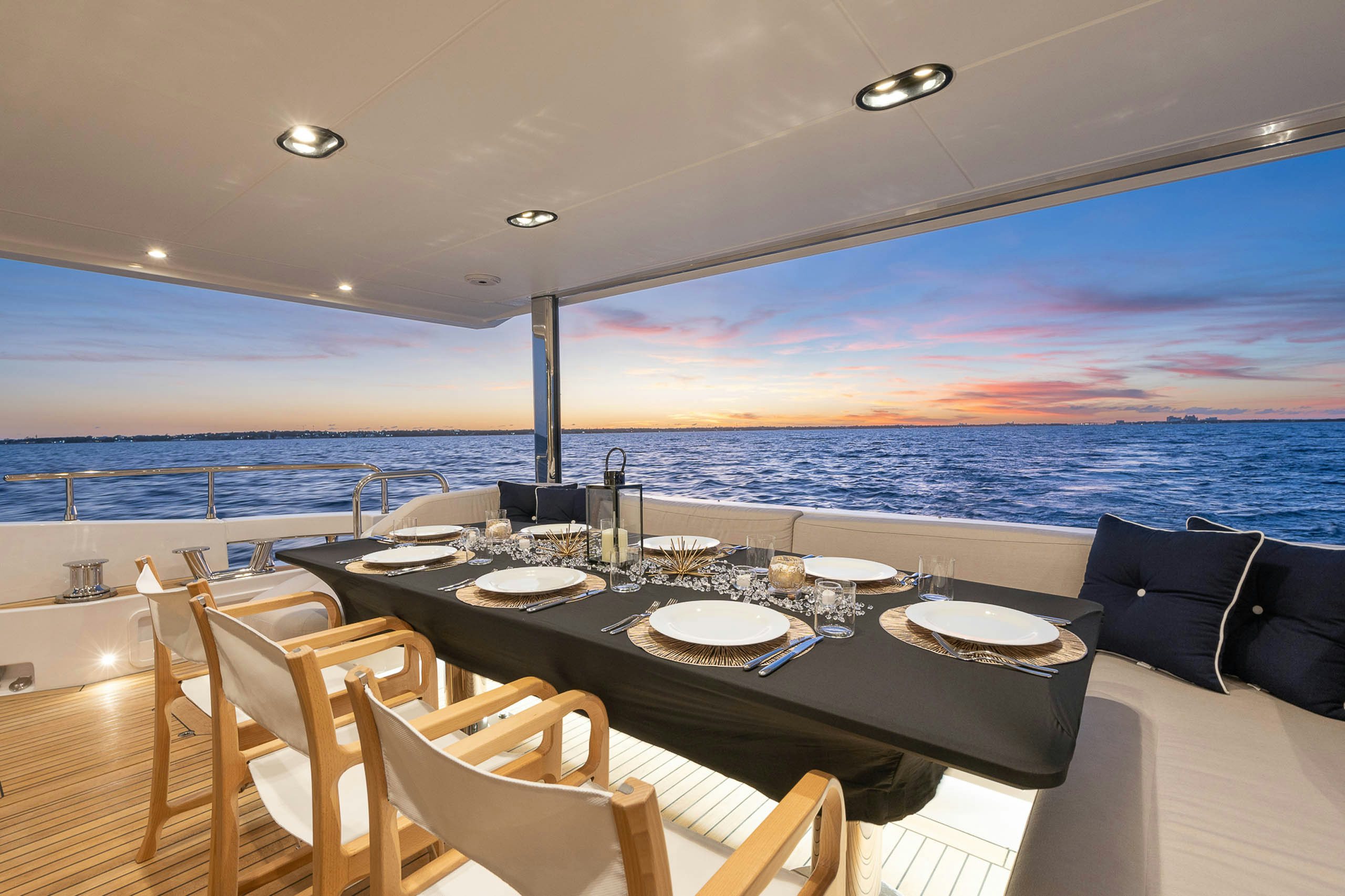 a dining table on a deck overlooking the ocean aboard SEA OWL Yacht for Charter