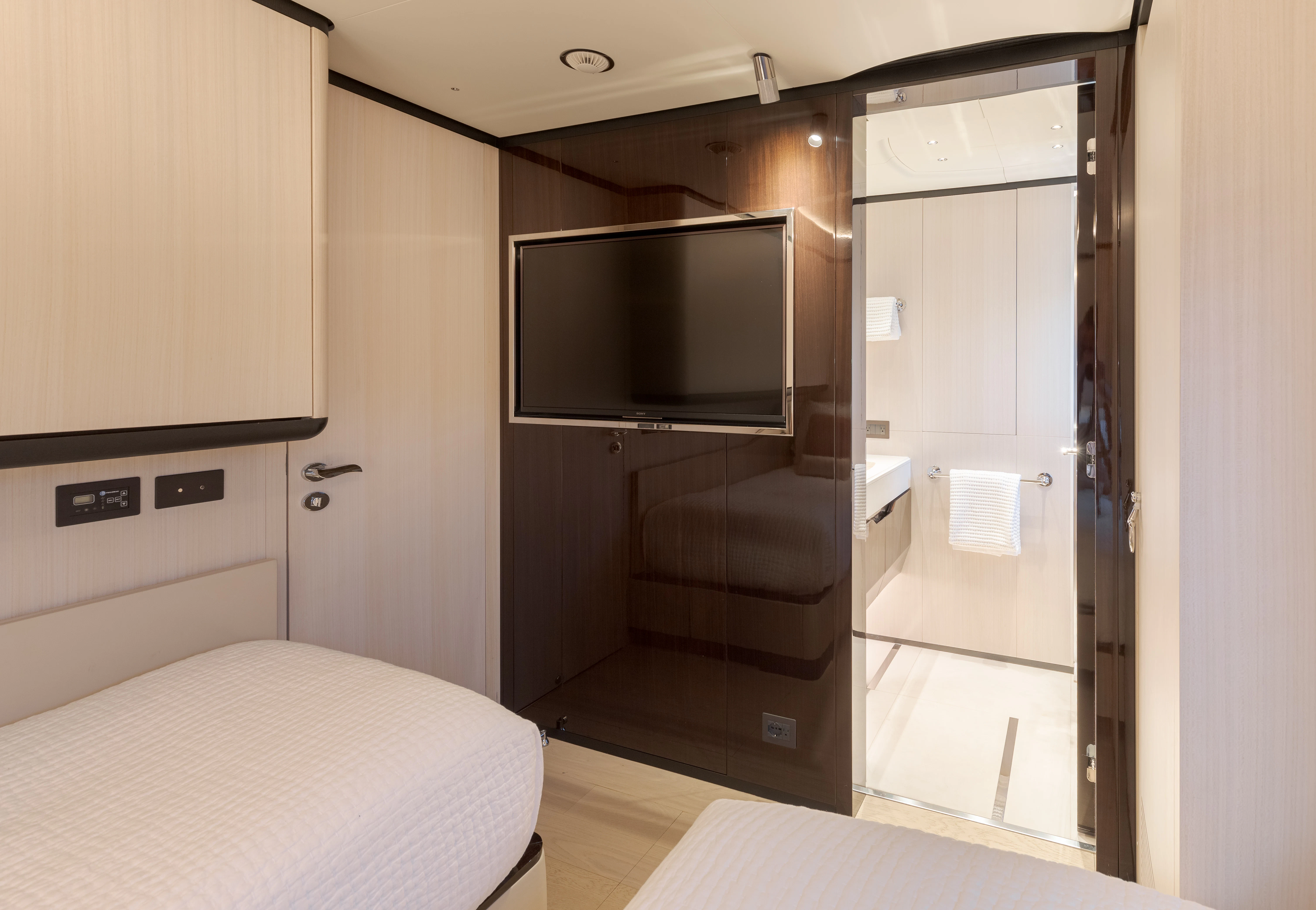 a room with a bed and a television aboard BELLA VITA Yacht for Charter