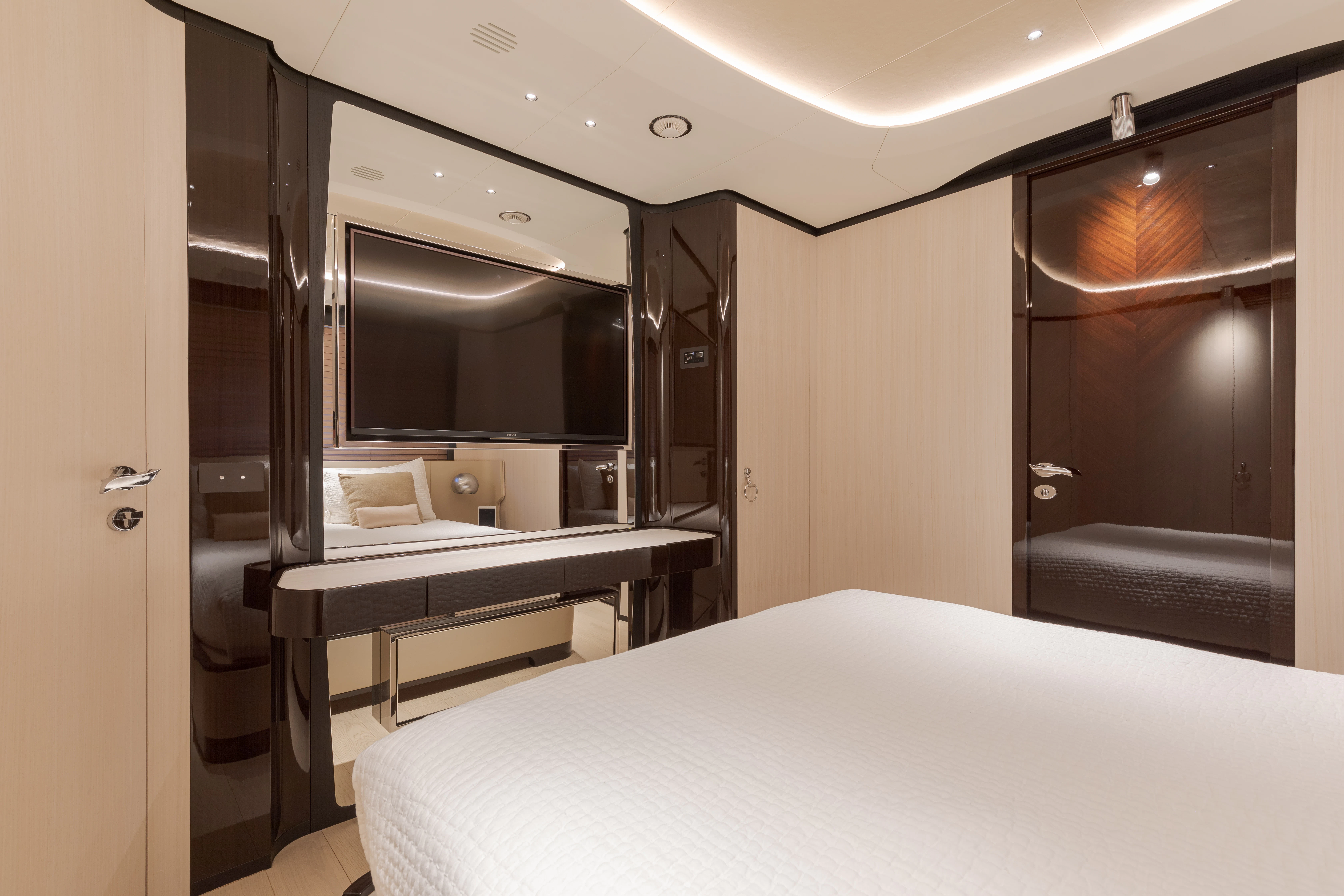 a room with a bed and desk aboard BELLA VITA Yacht for Charter