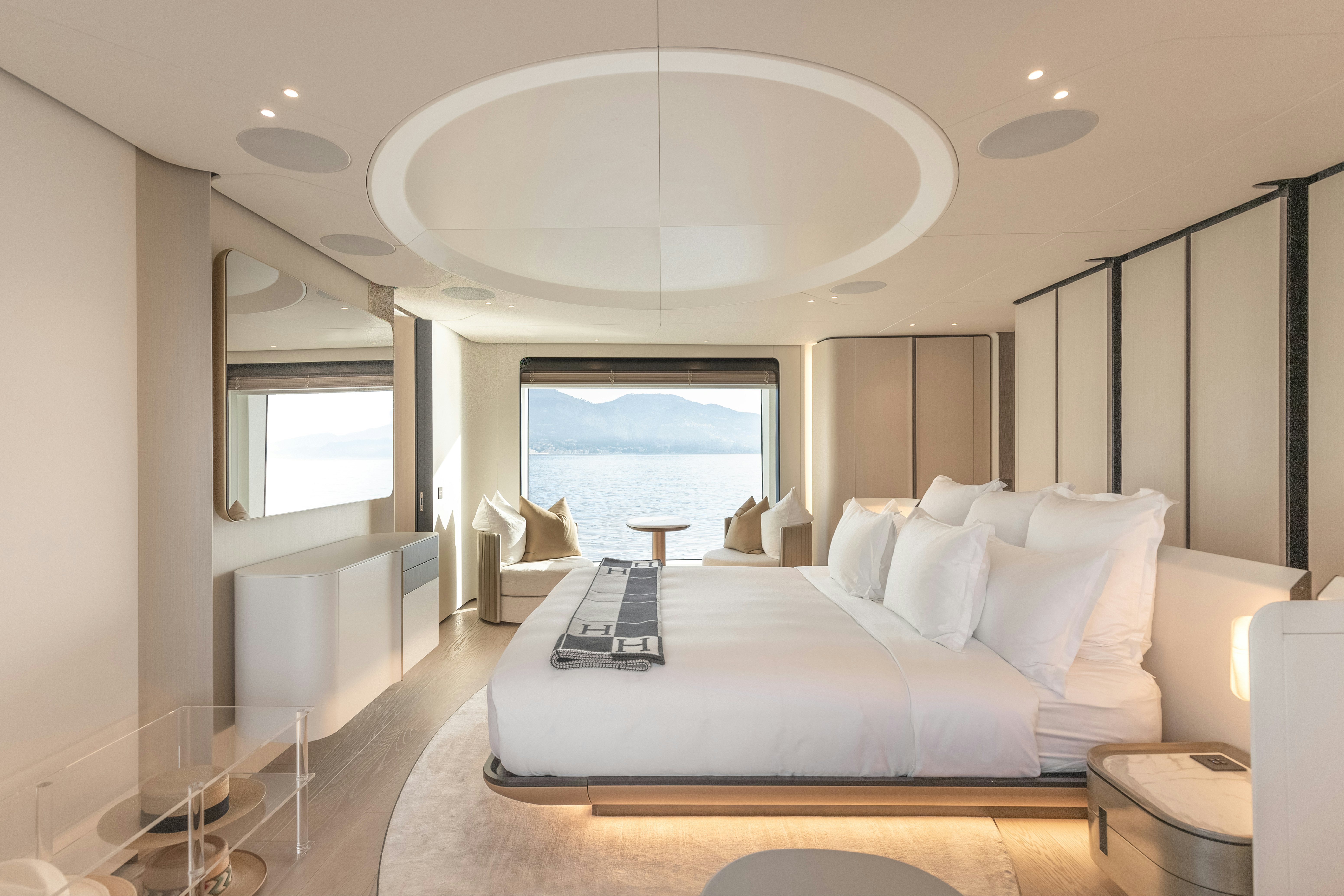 a large white bedroom with a large window aboard H Yacht for Sale