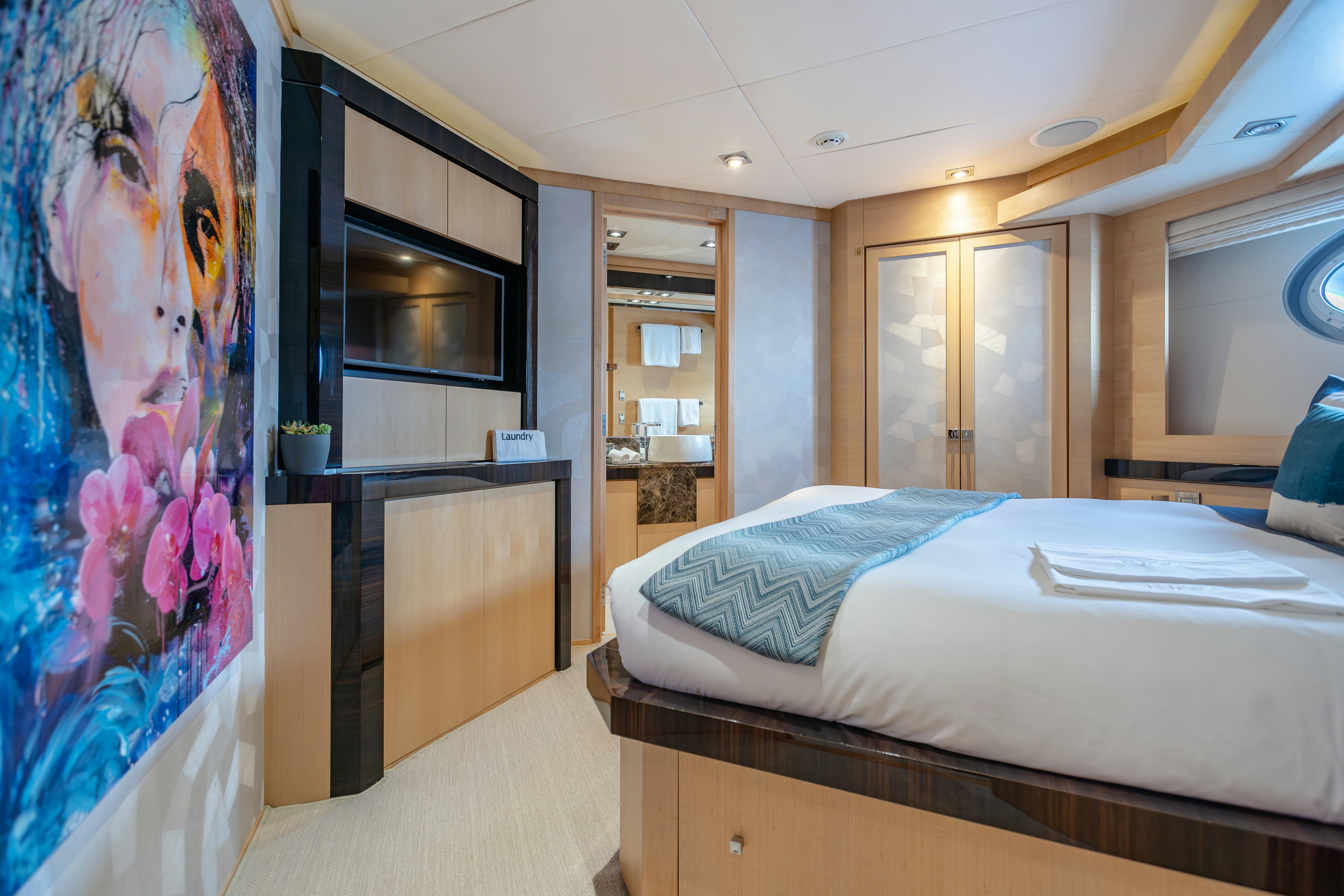 a bedroom with a bed and a large mirror aboard KJOS Yacht for Sale