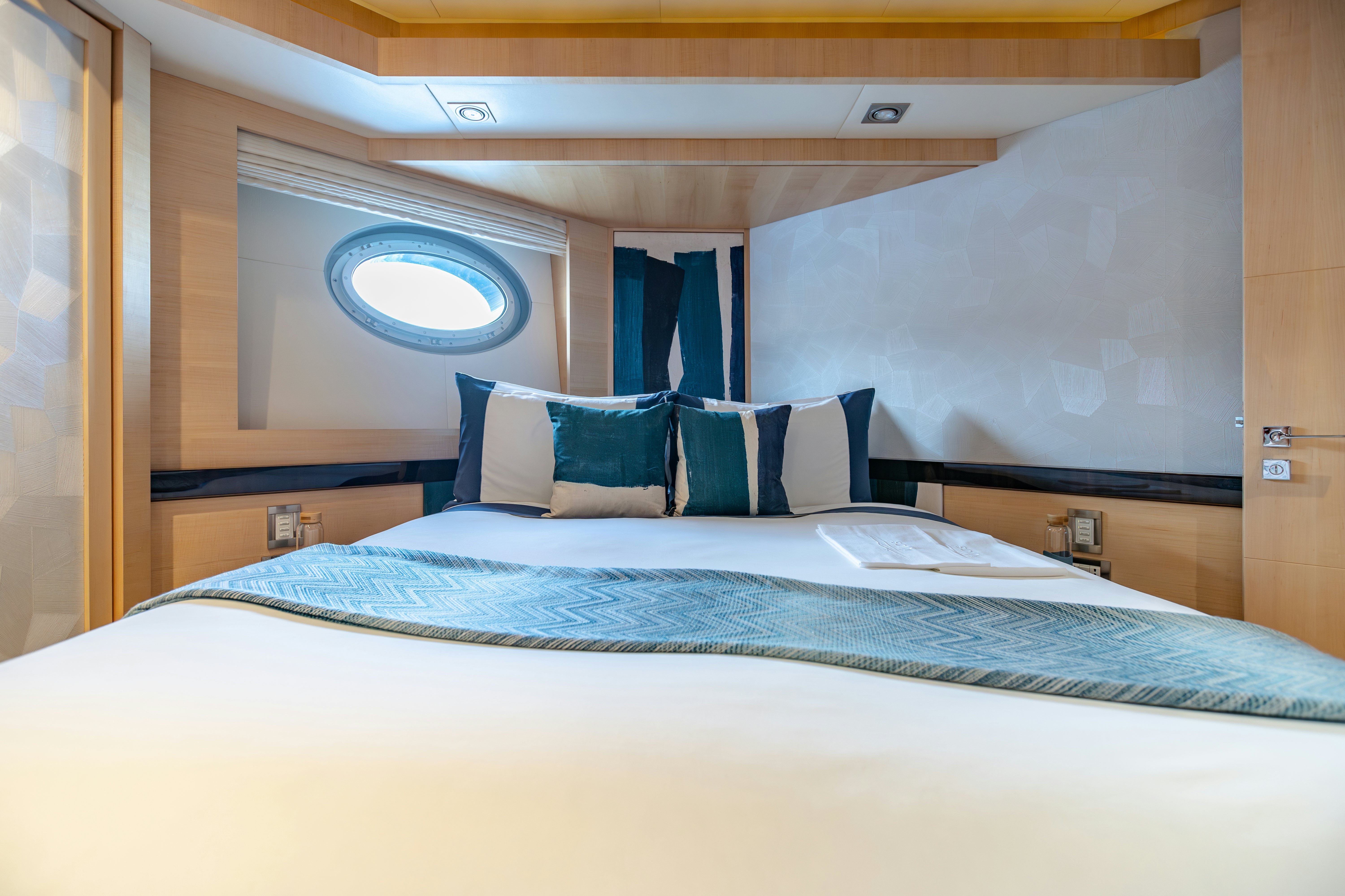 a bed with blue sheets aboard KJOS Yacht for Sale