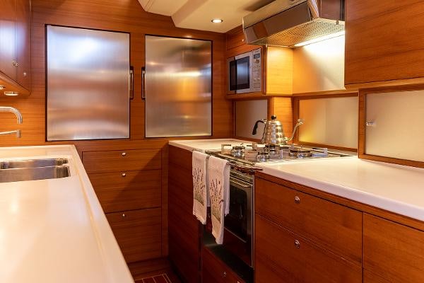 a kitchen with wooden cabinets aboard FRIDA Yacht for Sale