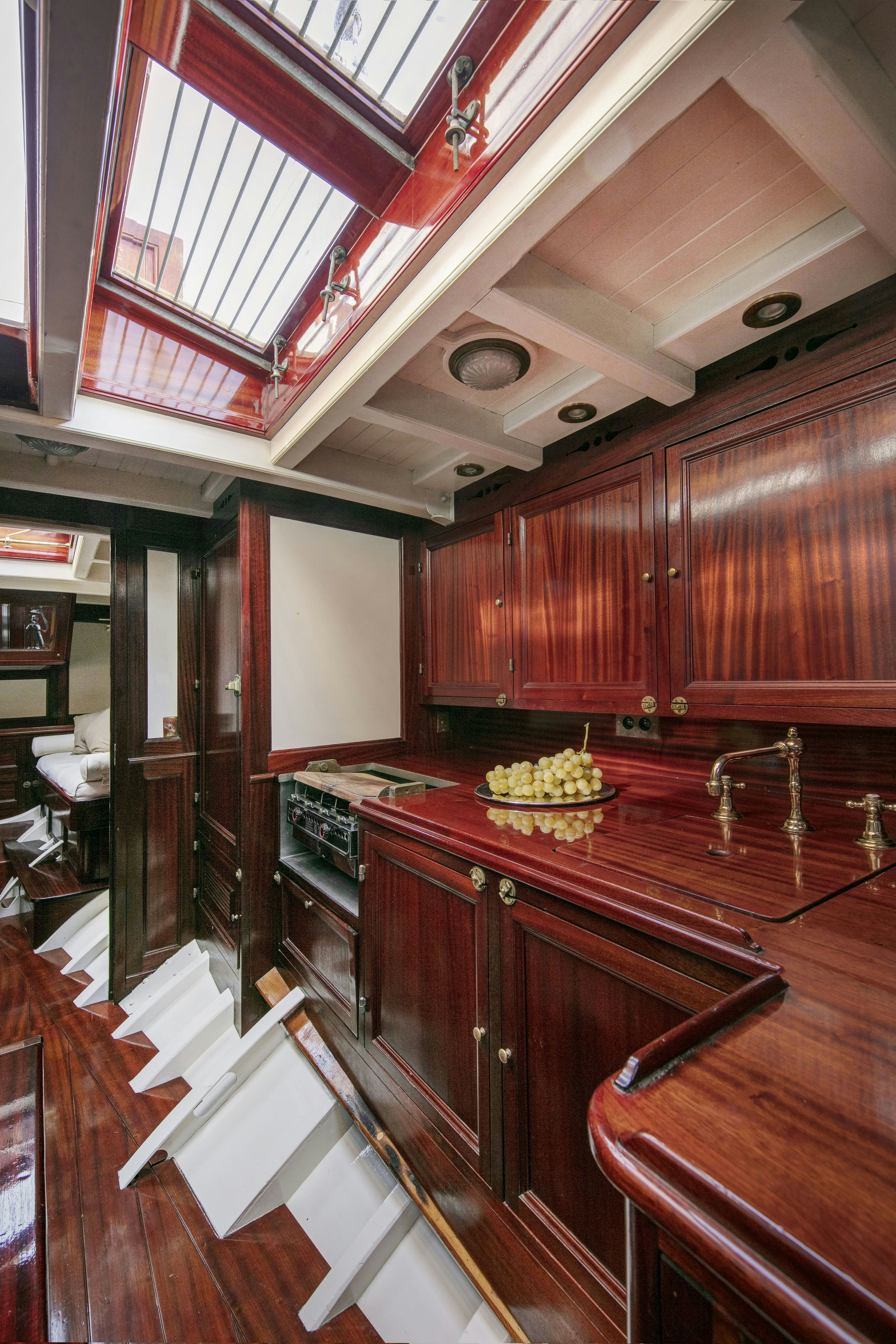 a kitchen with wooden cabinets aboard MARISKA Yacht for Sale