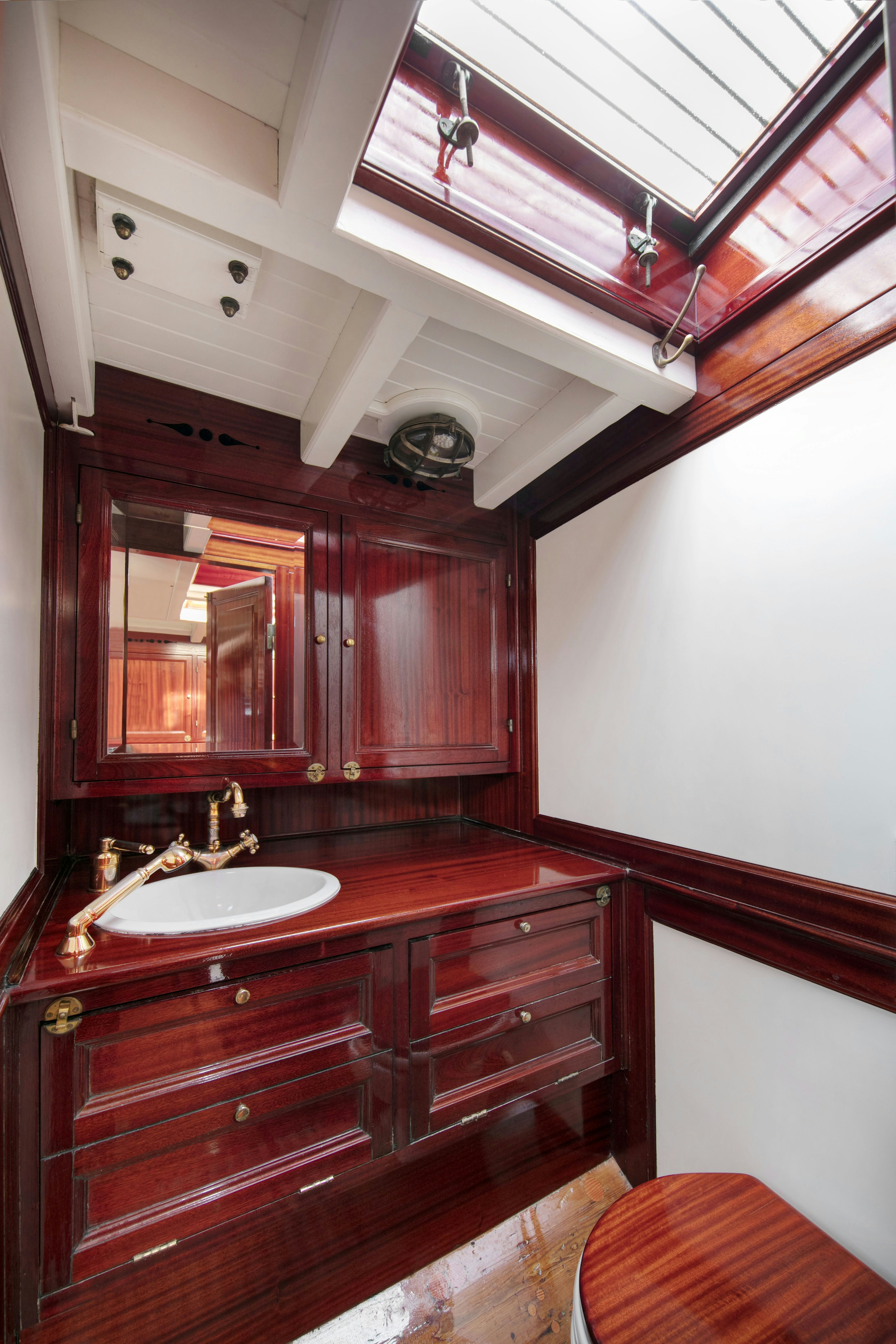a bathroom with wooden cabinets aboard MARISKA Yacht for Sale