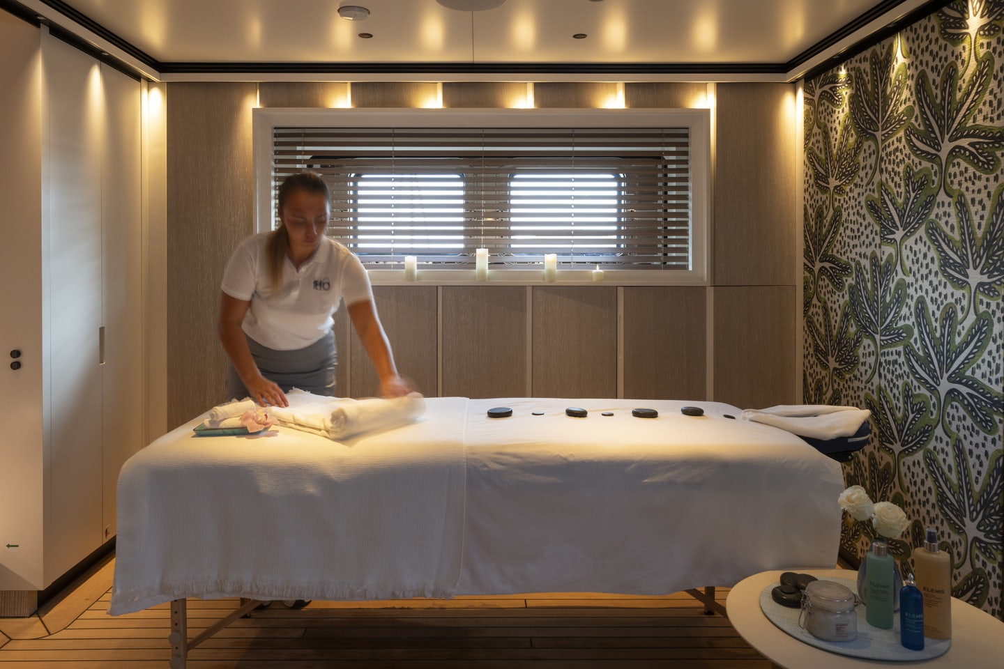 a person standing next to a bed aboard RIO Yacht for Charter