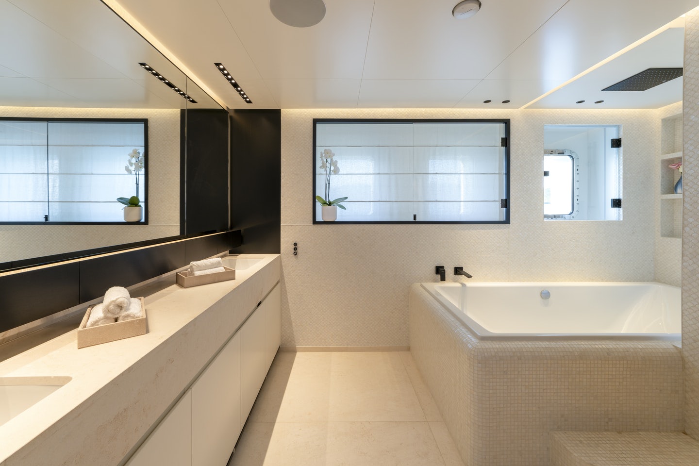 a bathroom with a tub sink and cabinets aboard RIO Yacht for Charter