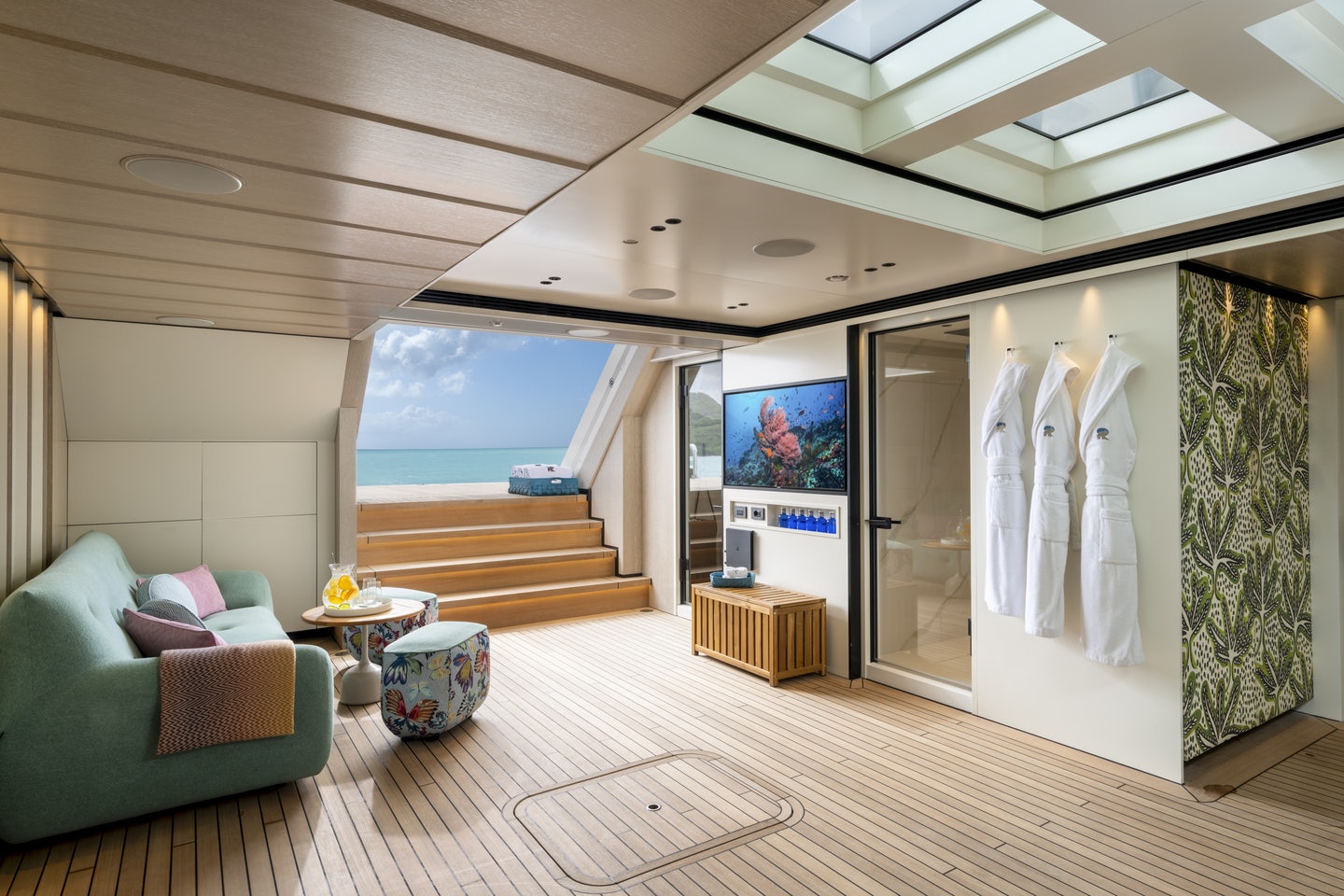 a room with a large window and a couch and a table aboard RIO Yacht for Charter