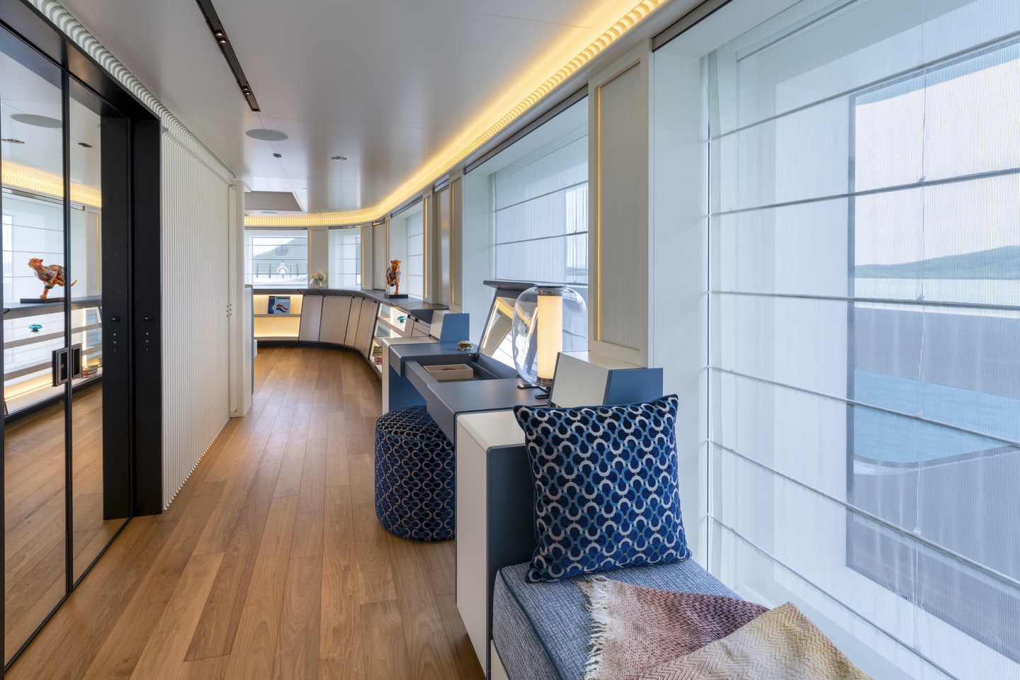 a room with a wood floor and a desk with a laptop on it aboard RIO Yacht for Charter