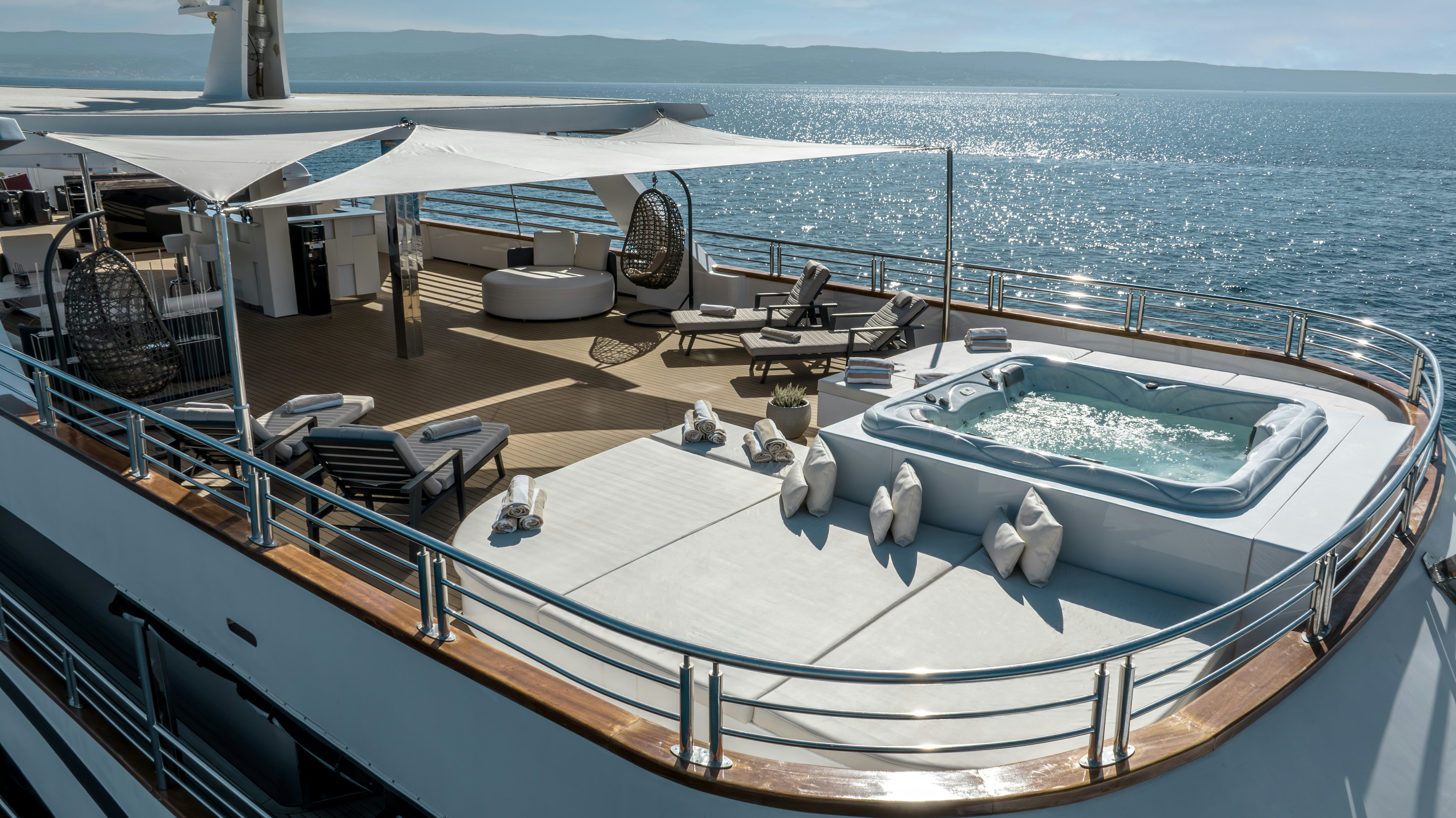 a deck with a large white boat and a large white boat on it aboard CRISTAL Yacht for Charter