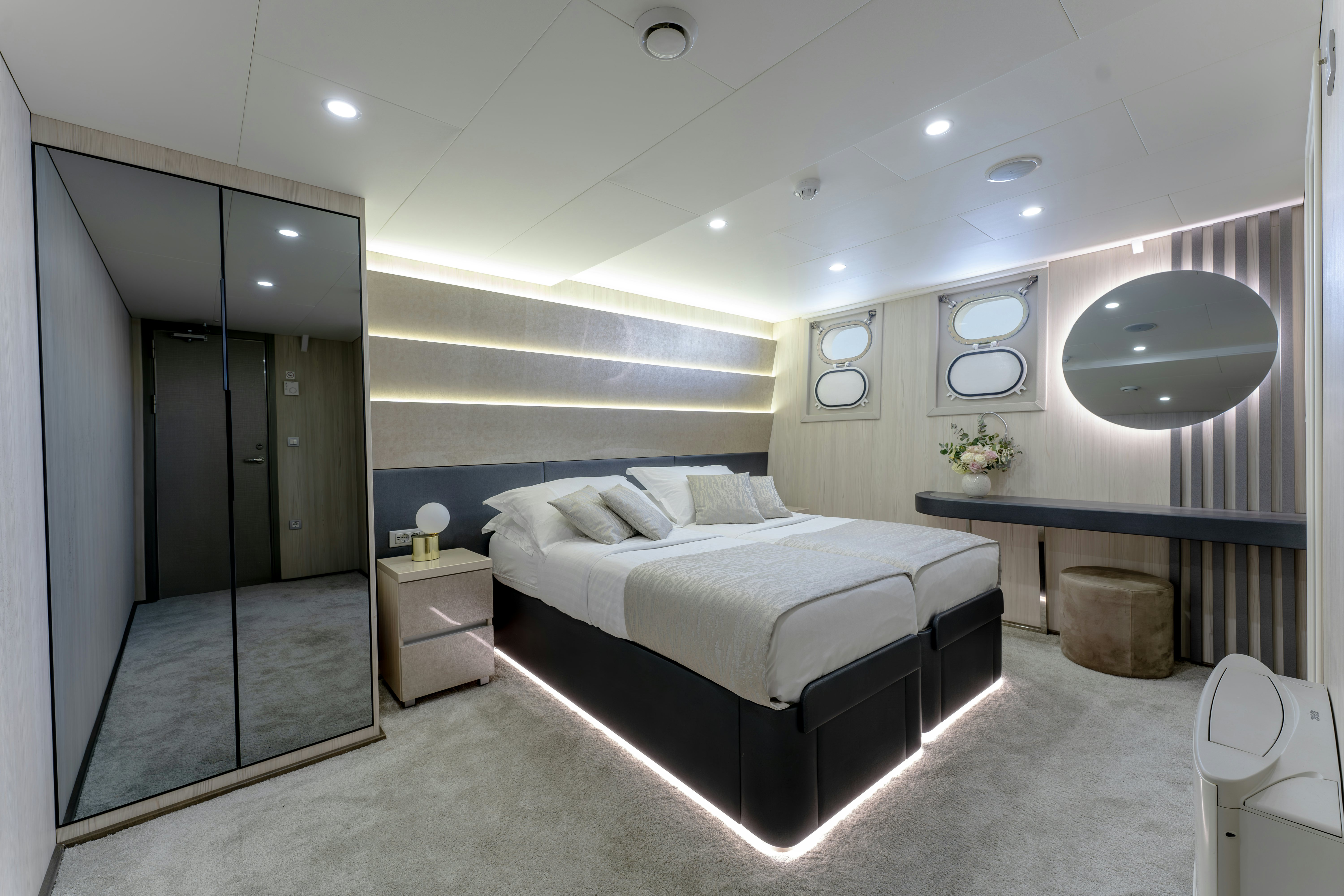 a bedroom with a bed and a mirror aboard CRISTAL Yacht for Charter