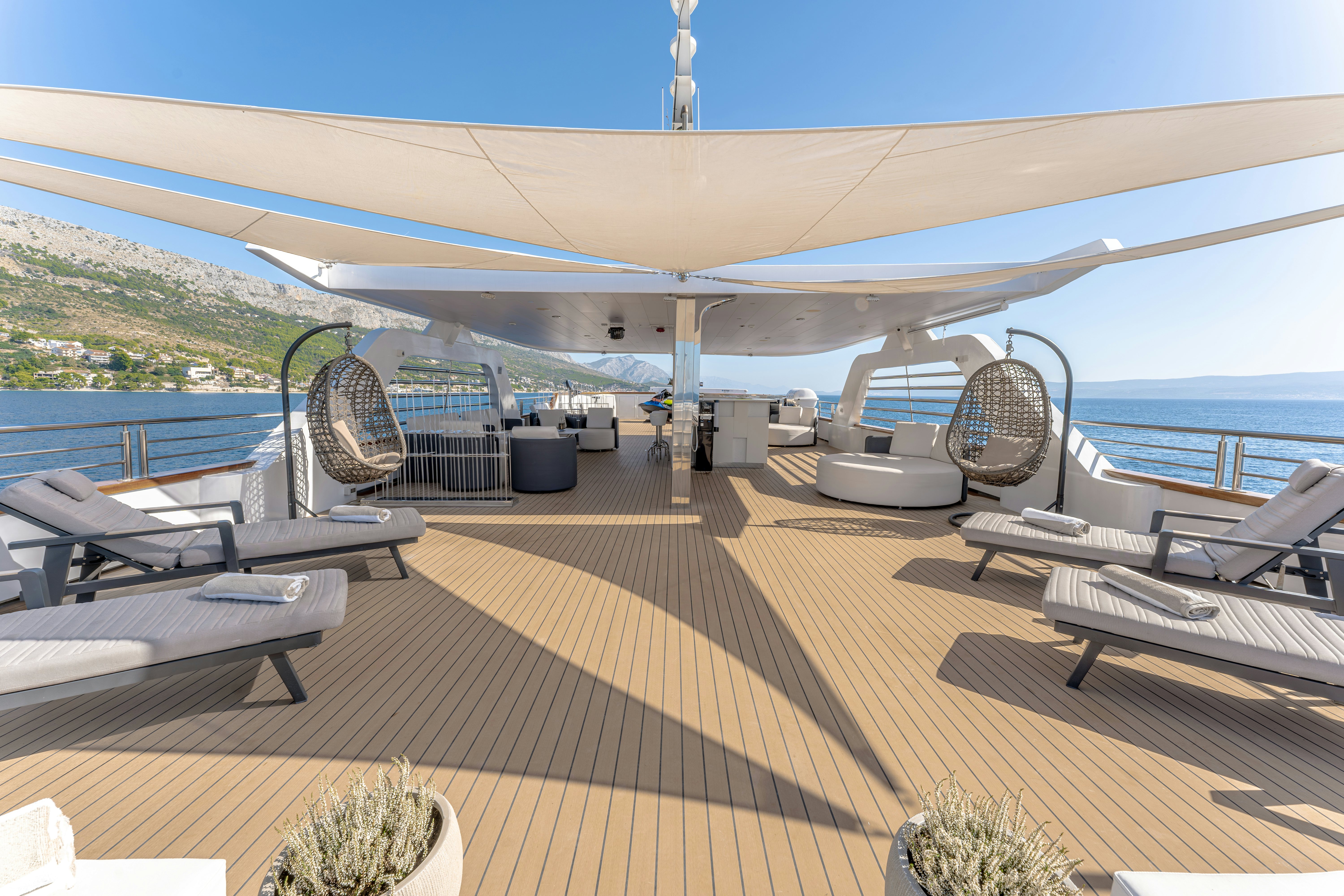 a deck with a large deck and a large ship in the water aboard CRISTAL Yacht for Charter