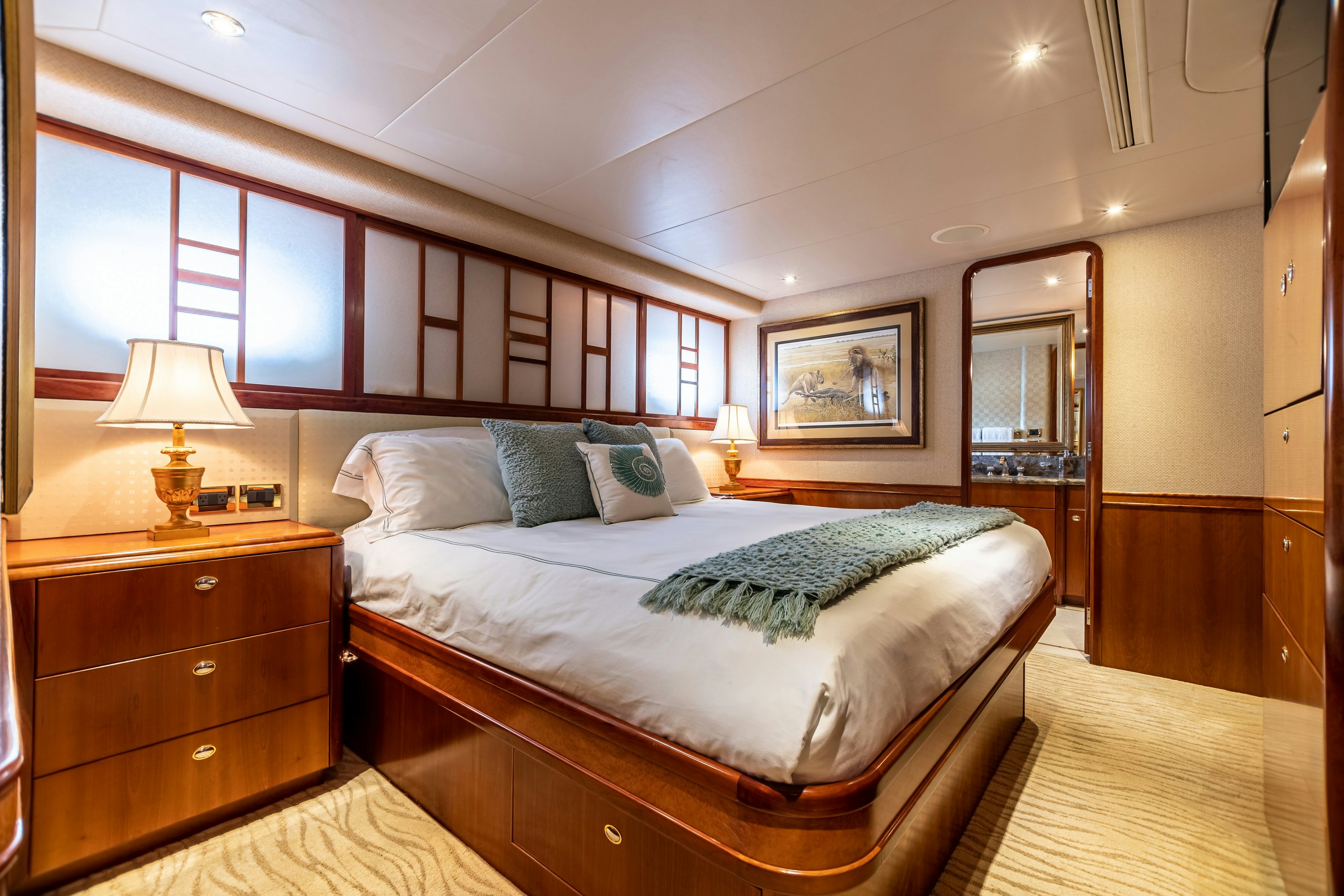 a bedroom with a bed and a dresser aboard SERENGETI Yacht for Charter