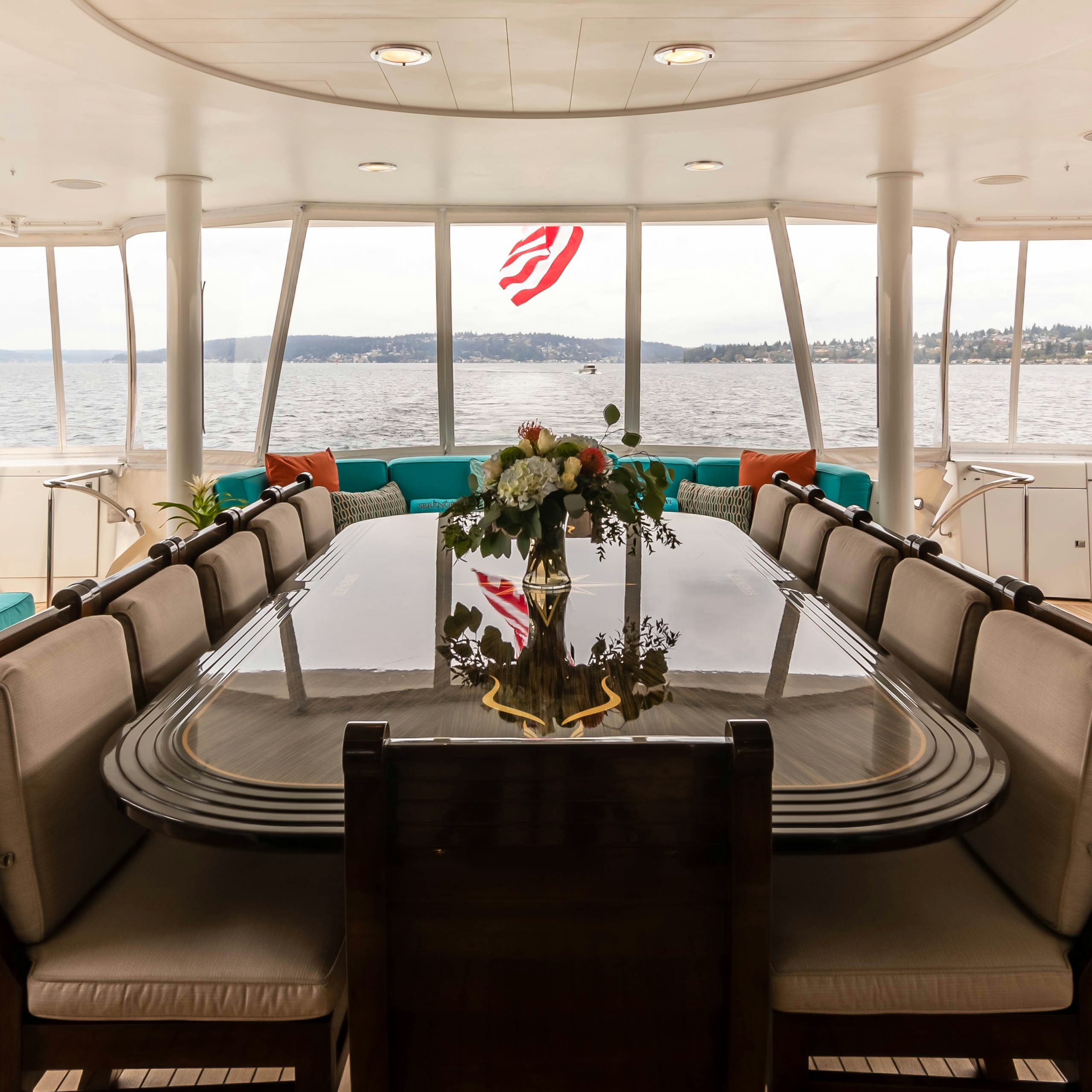 a table with chairs and a vase with flowers on it aboard SERENGETI Yacht for Charter