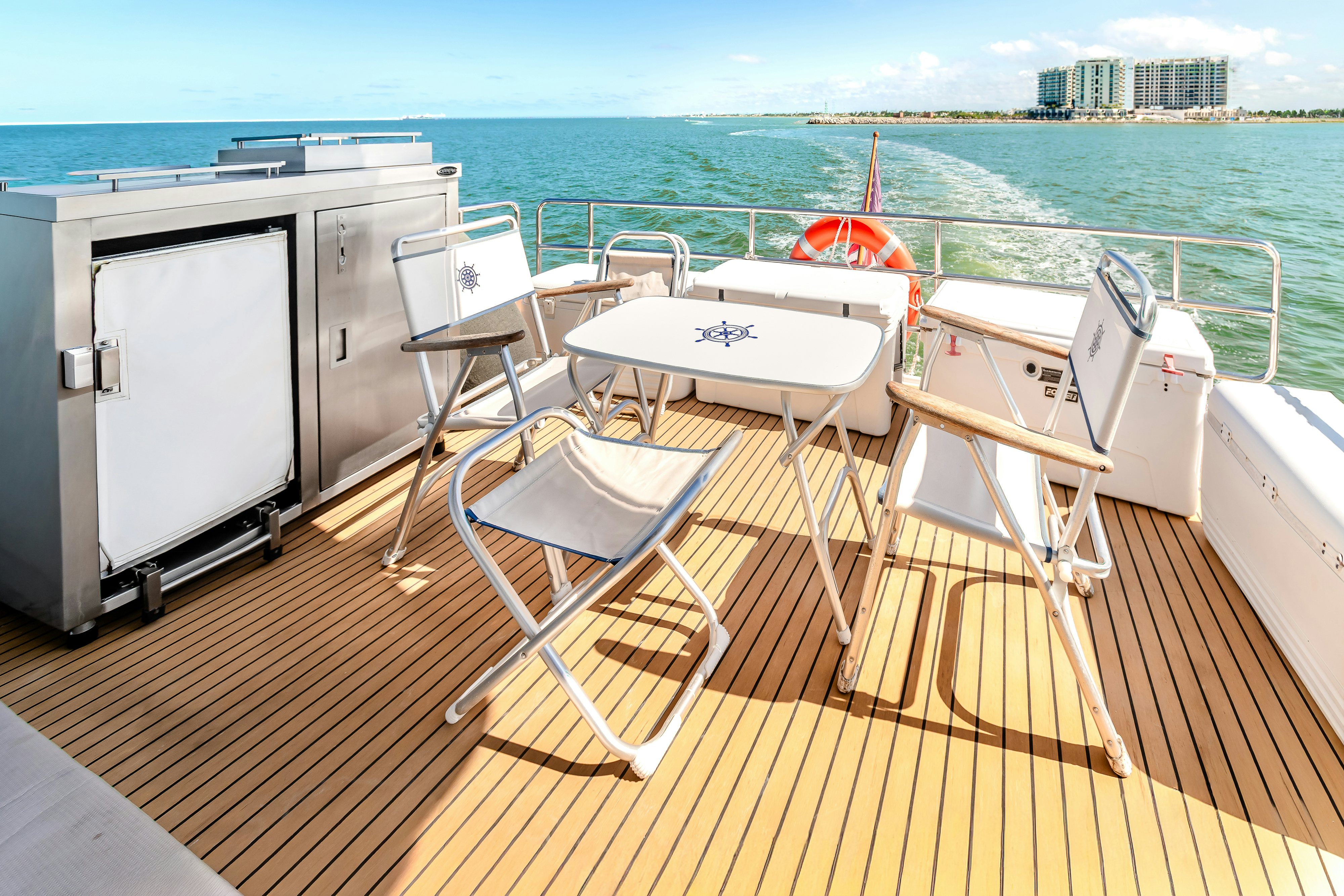 a deck with chairs and a table on it aboard VIAKAREY Yacht for Sale