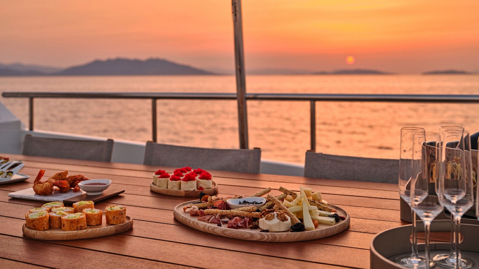 a table with food and glasses on it aboard GELLY Yacht for Charter