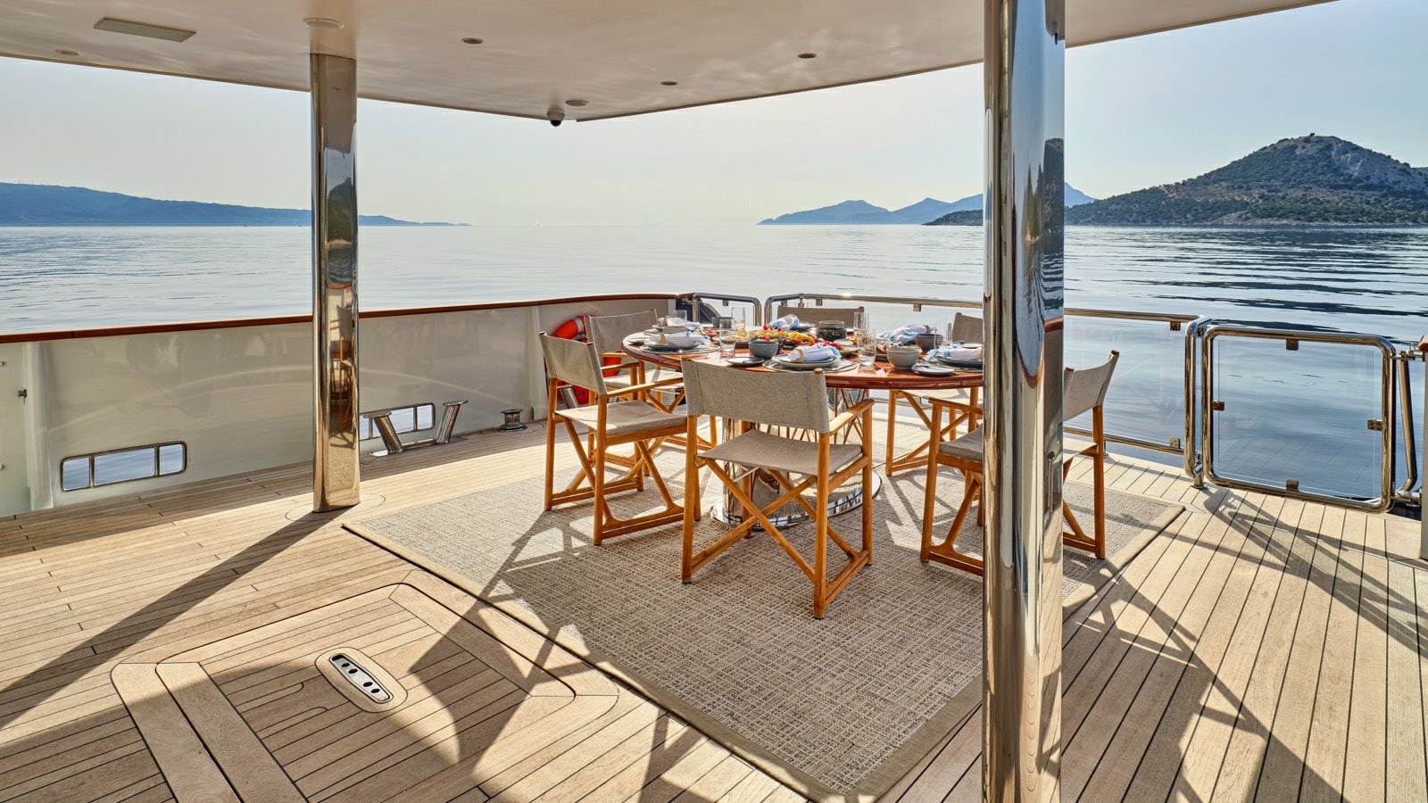 a deck with a table and chairs aboard GELLY Yacht for Charter