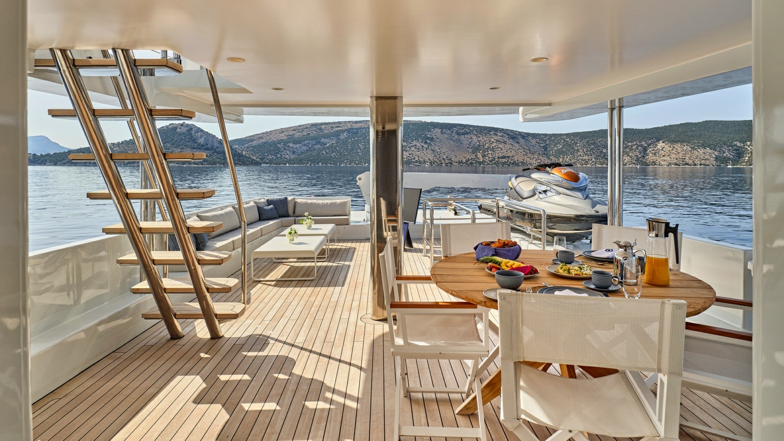 a deck with a table and chairs aboard GELLY Yacht for Charter