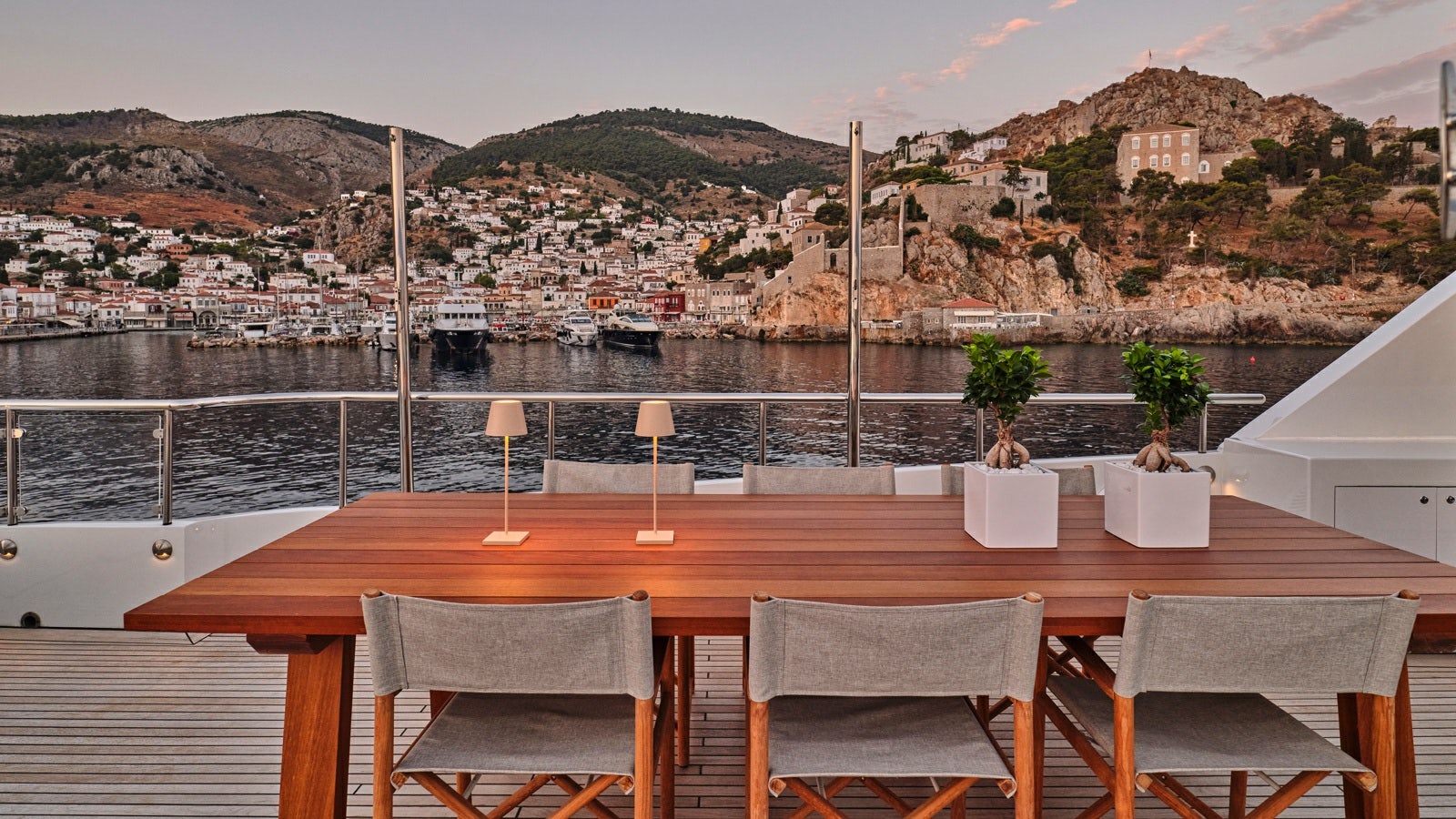 a table with chairs on it next to a body of water aboard GELLY Yacht for Charter