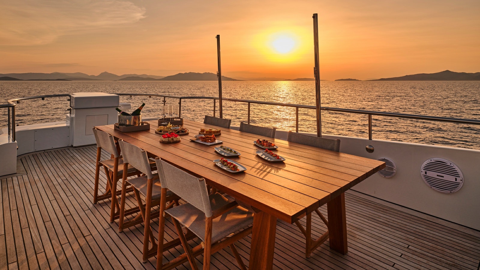 a table on a deck overlooking a body of water aboard GELLY Yacht for Charter
