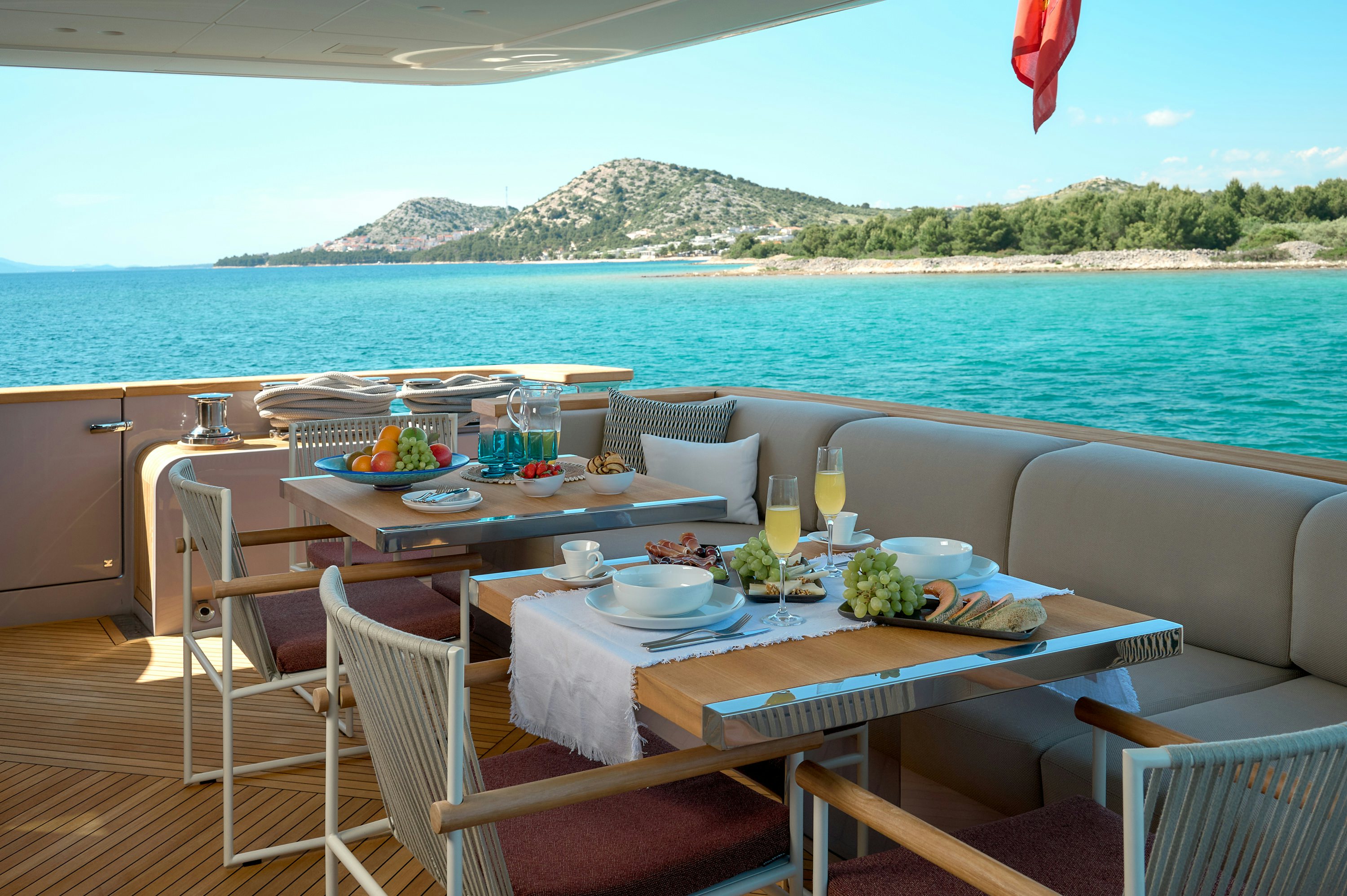 a table set for a meal on a balcony overlooking the ocean aboard AZZURRI Yacht for Charter