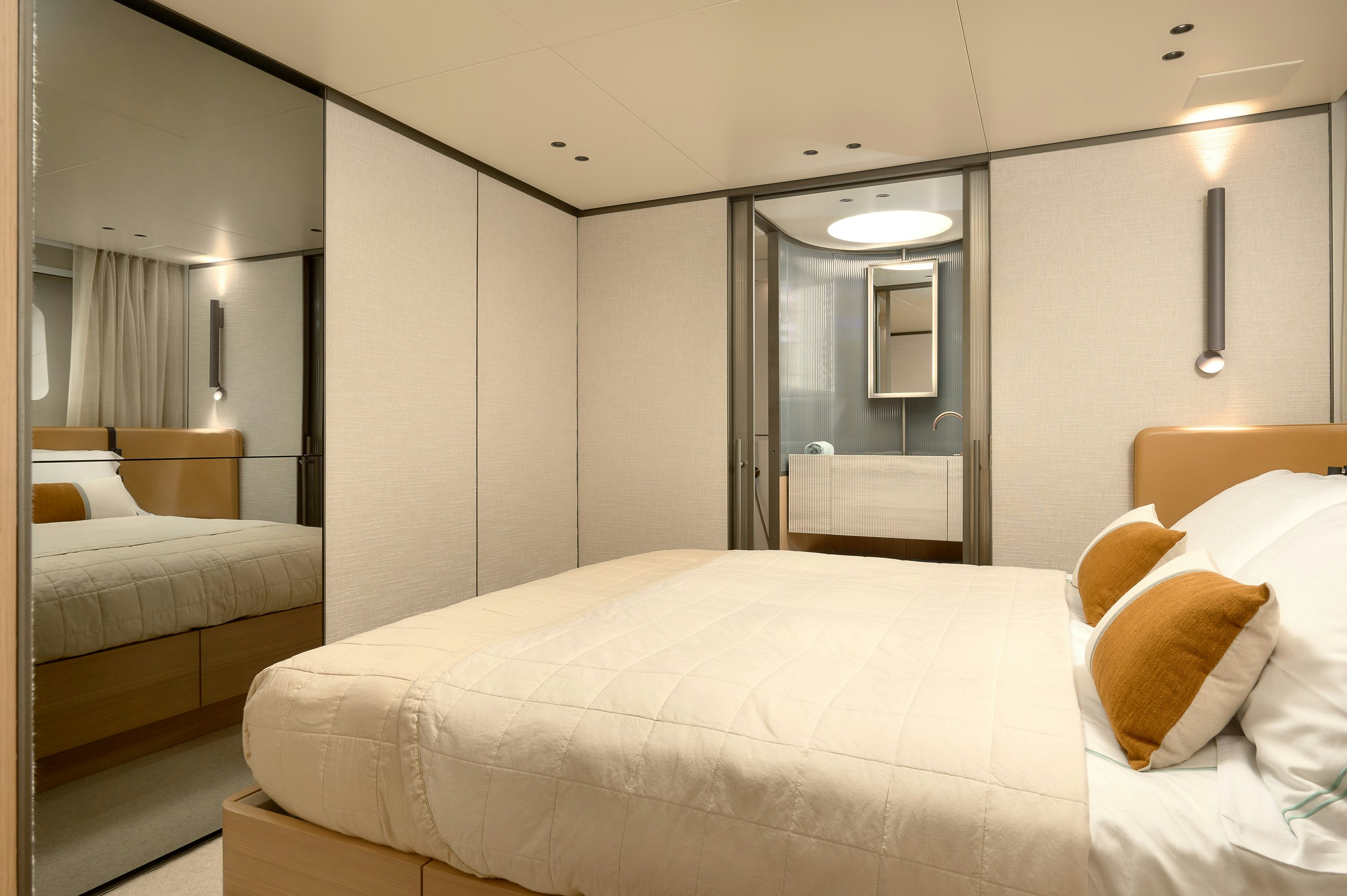 a hotel room with a bed and a mirror aboard AZZURRI Yacht for Charter