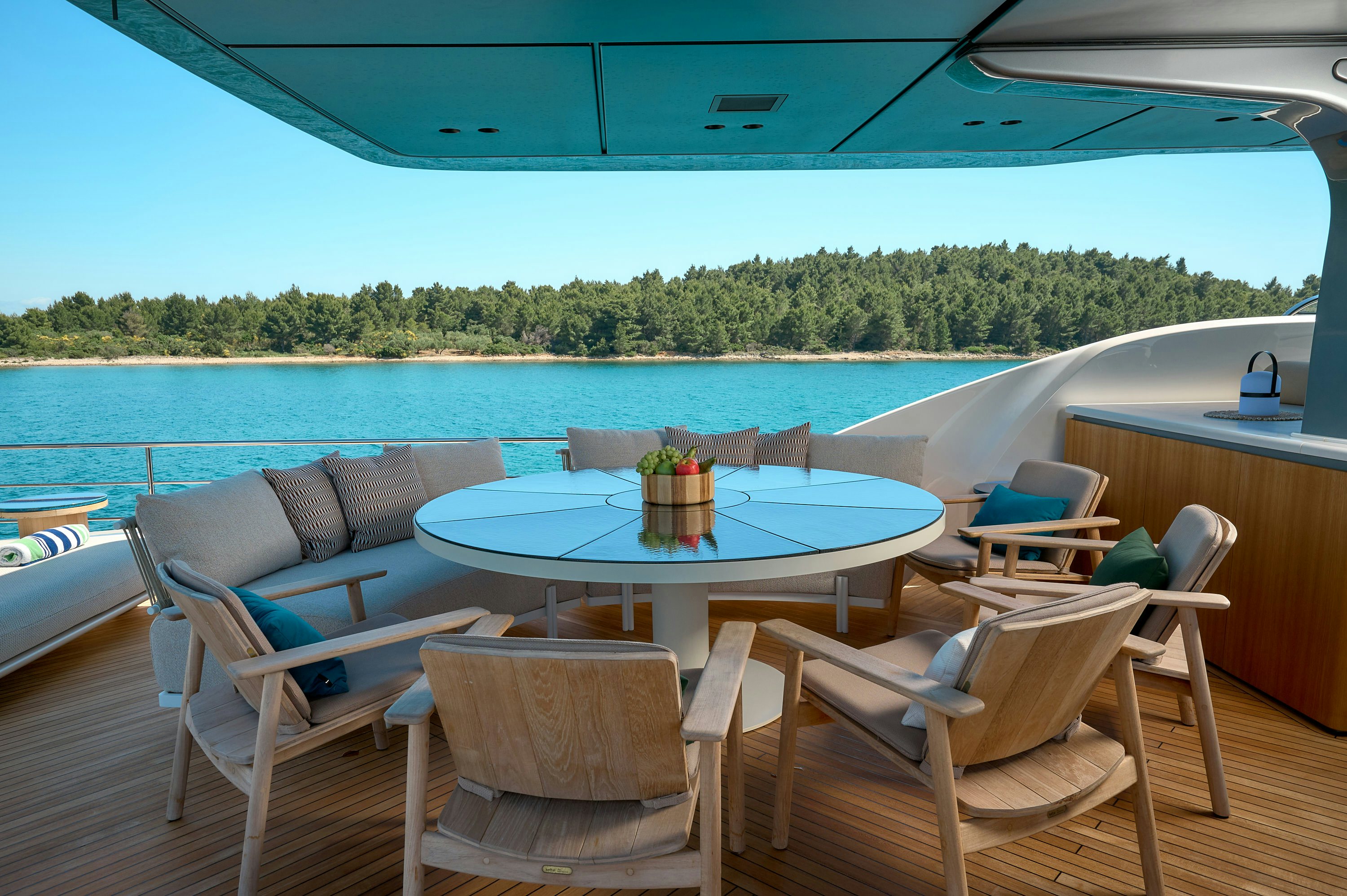 a table and chairs on a deck overlooking a body of water aboard AZZURRI Yacht for Charter