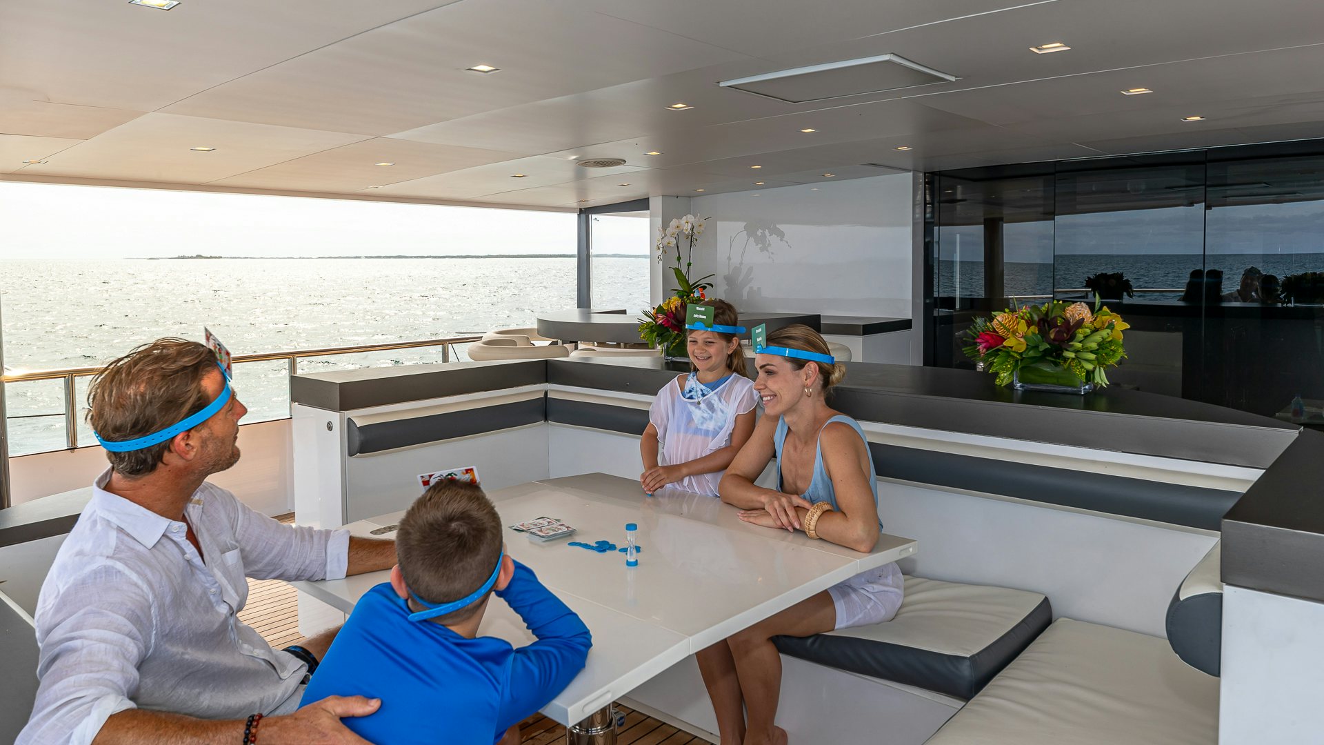a group of people sitting around a table aboard HIGHLANDER Yacht for Charter