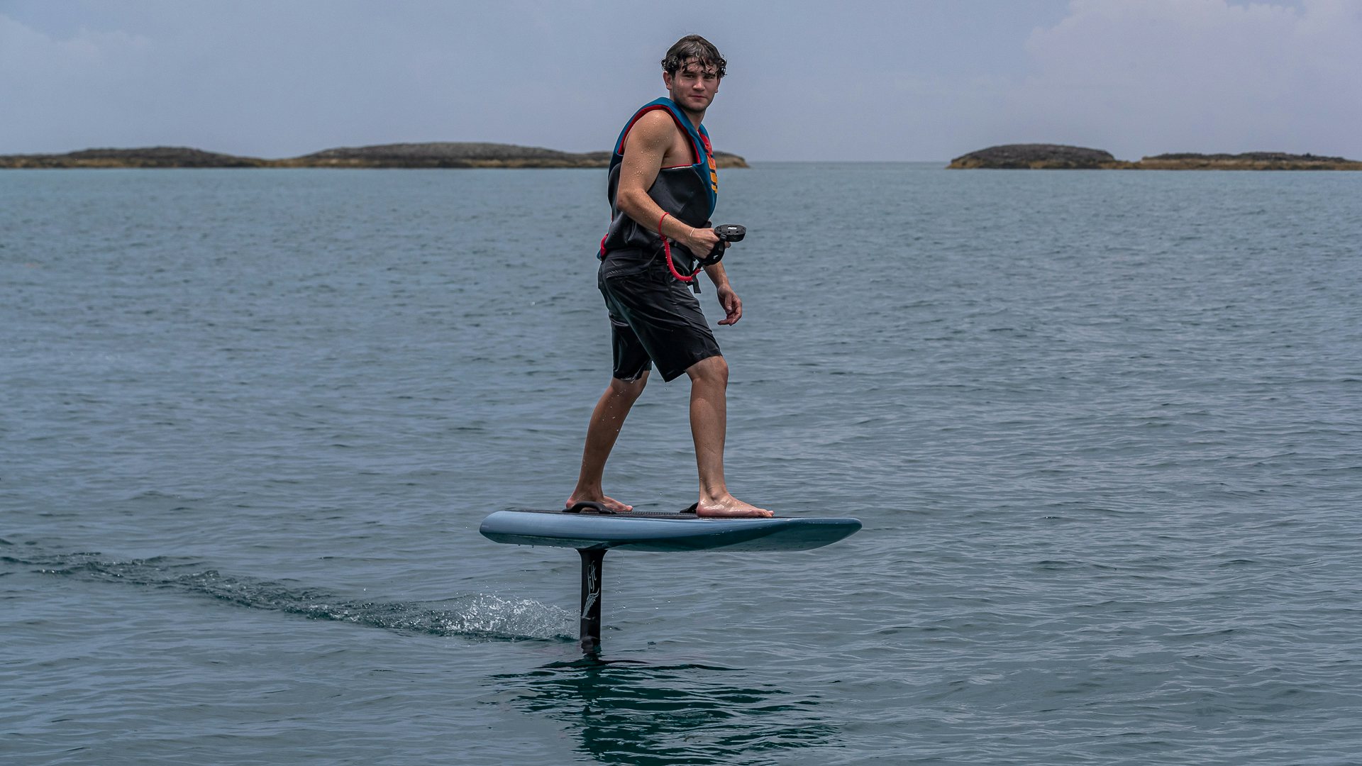 a man on a surfboard in the water aboard HIGHLANDER Yacht for Charter